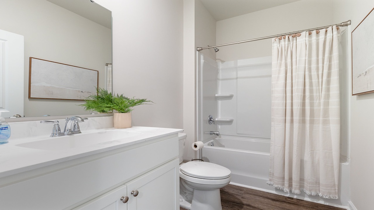secondary bathroom with white cabinets and a shower tub combo