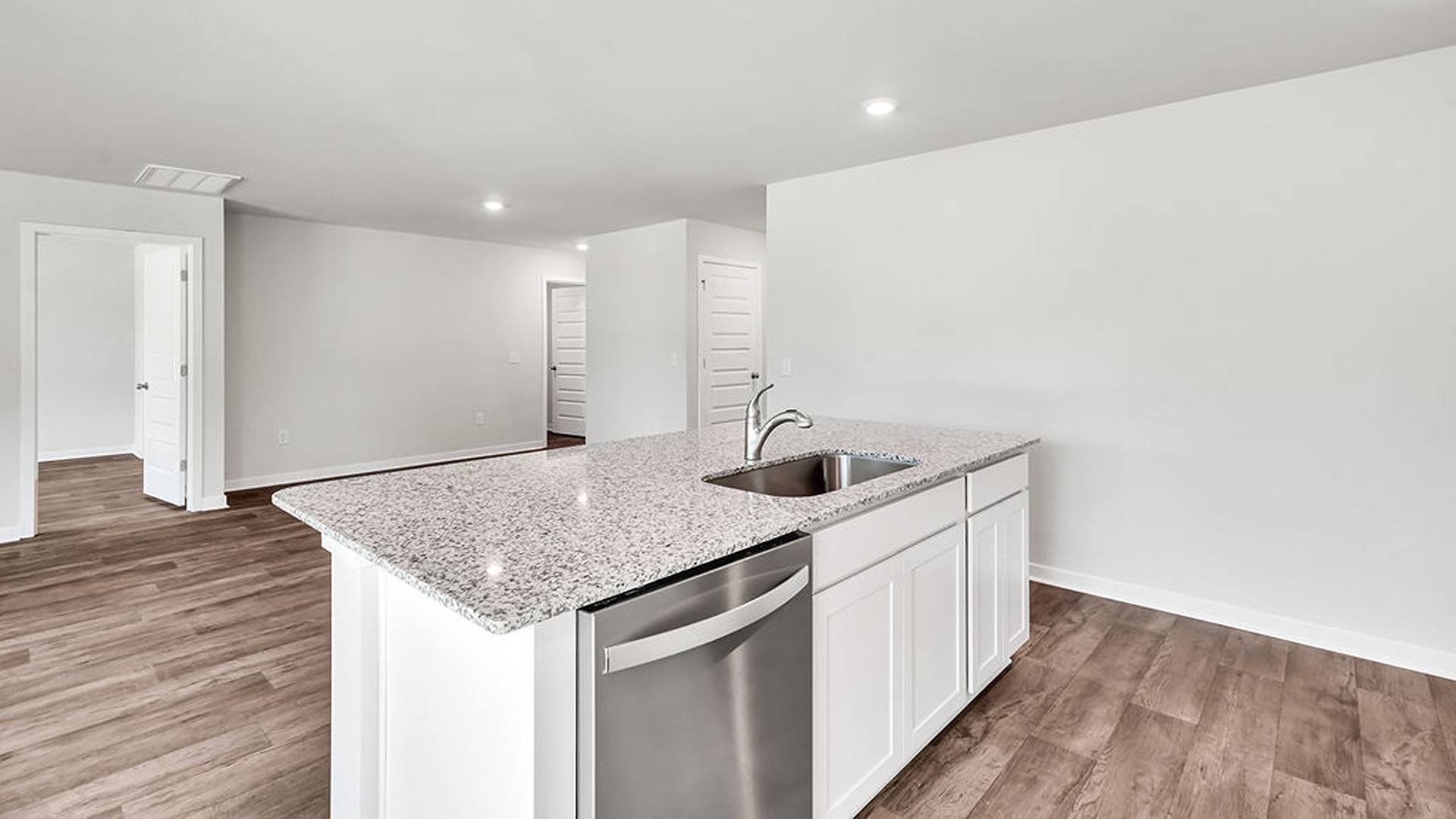 kitchen, and dining area feature granite countertops, stainless steel appliances, including a smooth-top range, dishwasher, and overhead microwave.