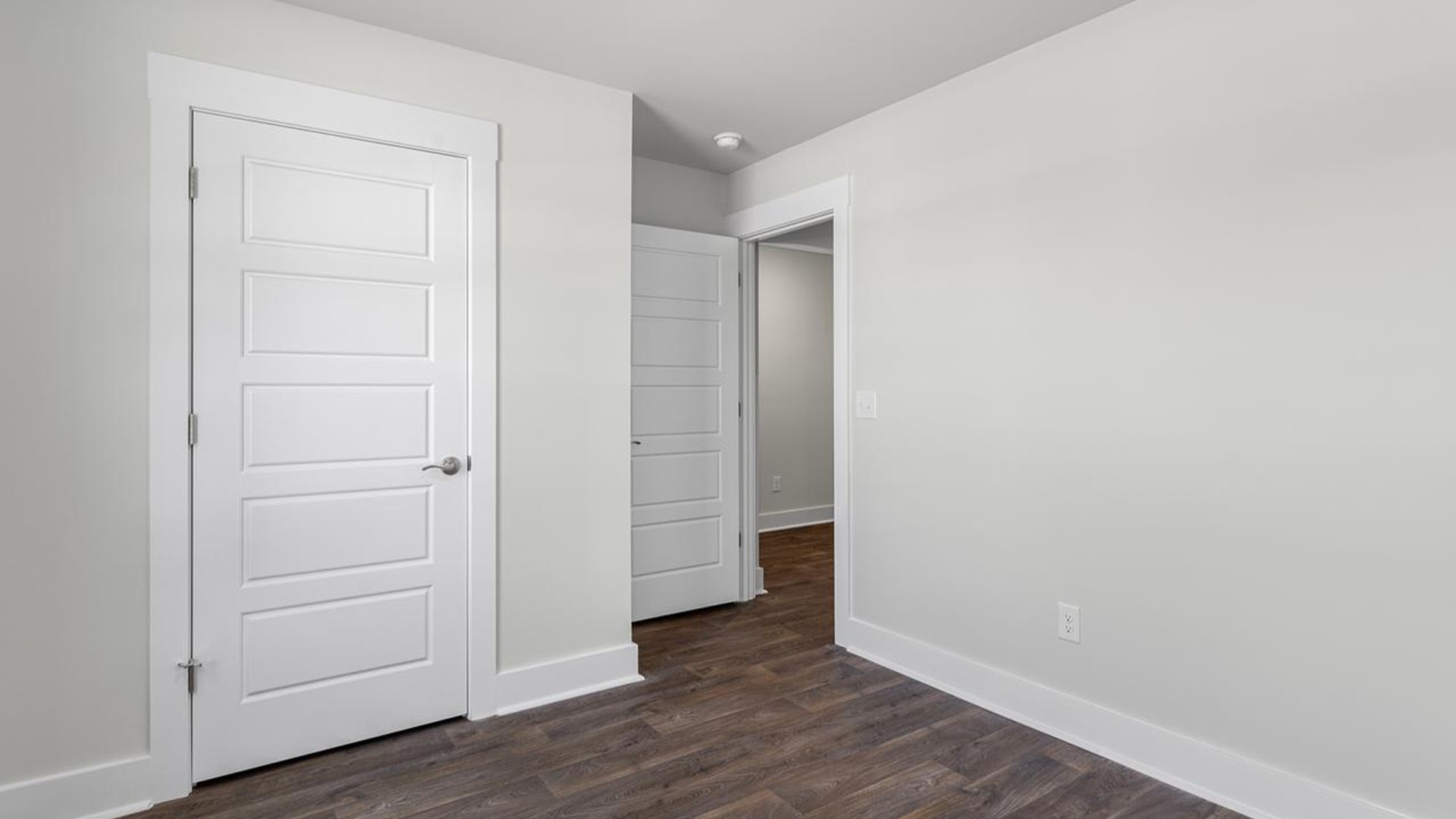 At the front are two guest bedrooms and a full bathroom, perfect for visitors or a home office. The open-concept family room,
