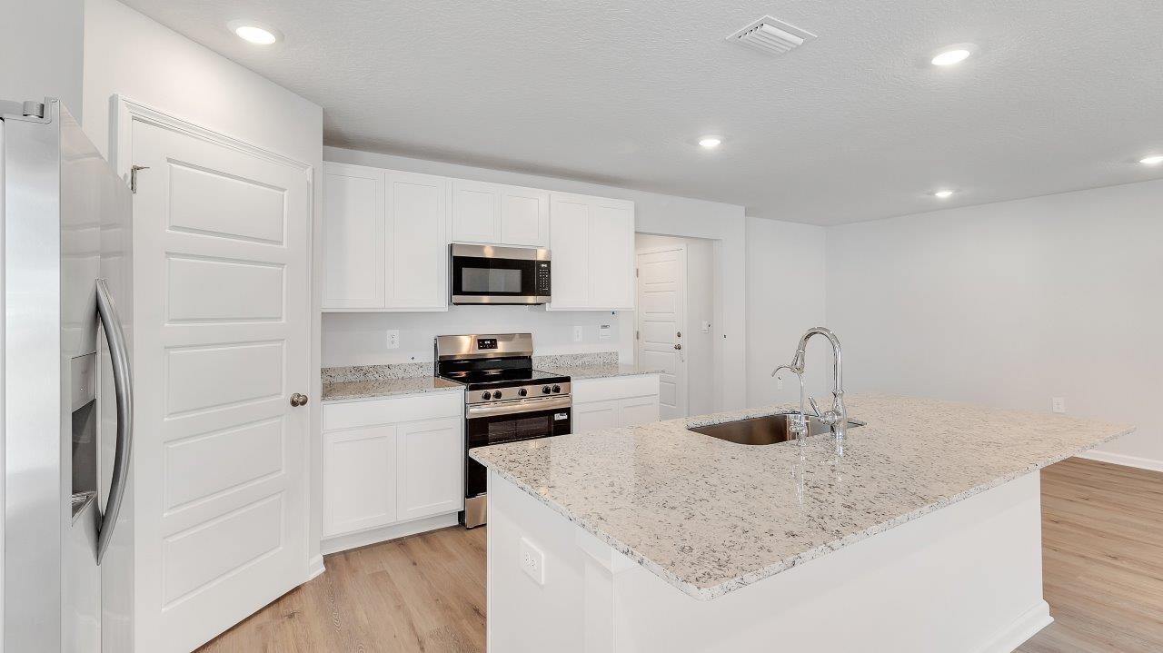 The kitchen boasts a stunning design featuring granite countertops, spacious island bar, stainless-steel appliances and a corner pantry. The kitchen boasts a stunning design featuring granite countertops, spacious island bar, stainless-steel appliances and a corner pantry.