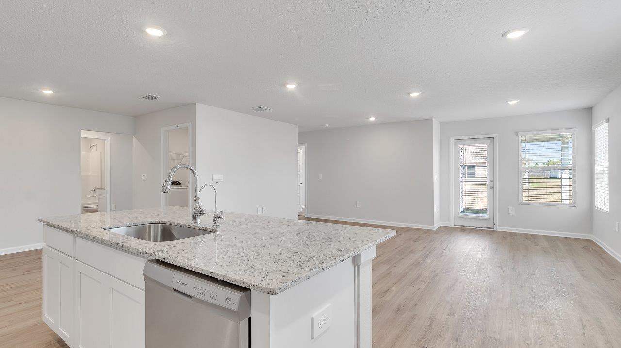 The kitchen boasts a stunning design featuring granite countertops, spacious island bar, stainless-steel appliances and a corner pantry.