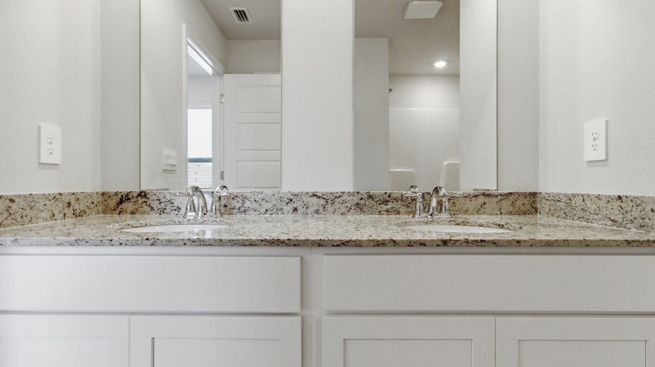 To the opposite side of the home are two bedrooms, a full bathroom with a linen closet and the laundry room. Y