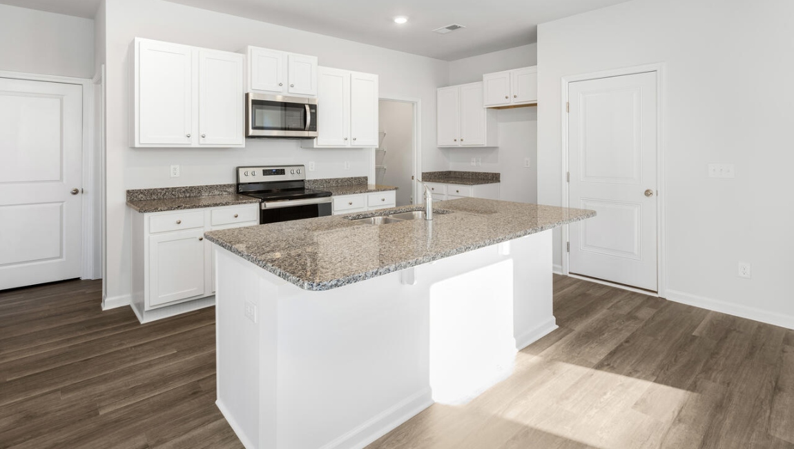This new home kitchen features stainless steel appliances, granite countertops and smooth-top electric range, microwave and dishwasher. Plenty of cabinet space.