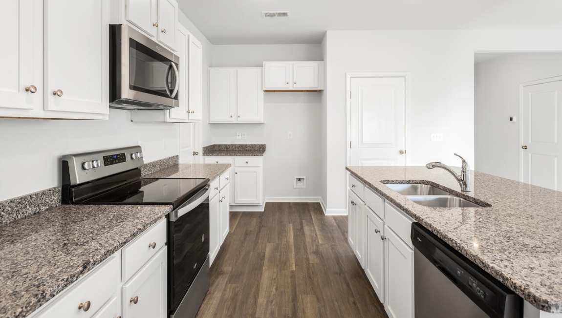 This new home kitchen features stainless steel appliances, granite countertops and smooth-top electric range, microwave and dishwasher. Plenty of cabinet space.