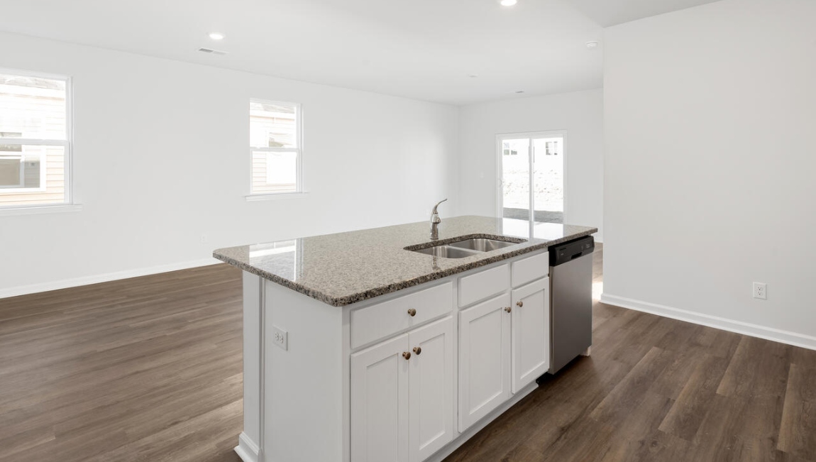 This new home kitchen features stainless steel appliances, granite countertops and smooth-top electric range, microwave and dishwasher. Plenty of cabinet space.