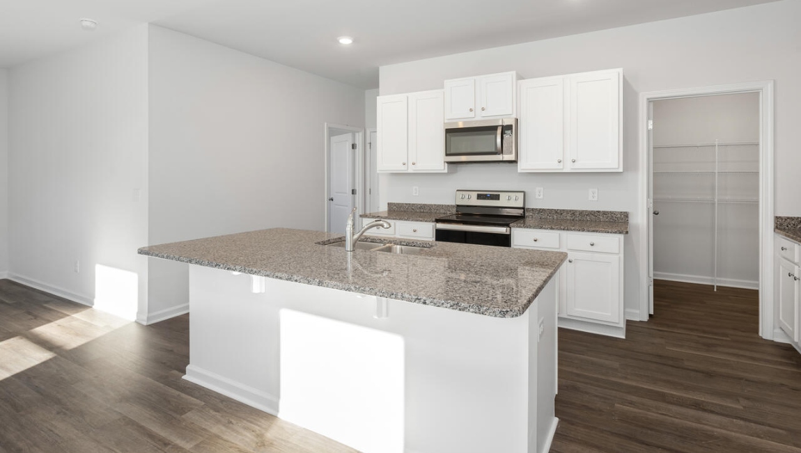 This new home kitchen features stainless steel appliances, granite countertops and smooth-top electric range, microwave and dishwasher. Plenty of cabinet space.
