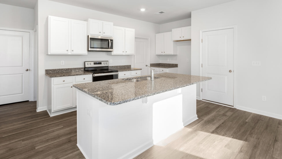 This new home kitchen features stainless steel appliances, granite countertops and smooth-top electric range, microwave and dishwasher. Plenty of cabinet space.