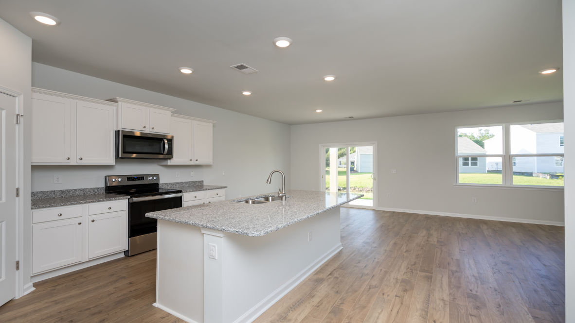 The kitchen features granite countertops, stainless steel appliances and boasts a large island with room for seating and opens to the casual dining area and spacious family room.