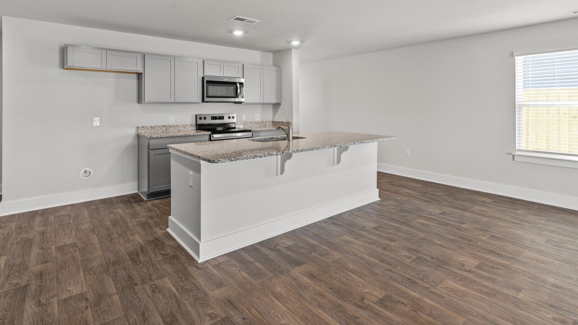 The kitchen features beautiful cabinets, granite countertops, and stainless steel appliances, which are sure to both turn heads and make meal prep easy. You’ll never be too far from the action with the living and dining area right there.