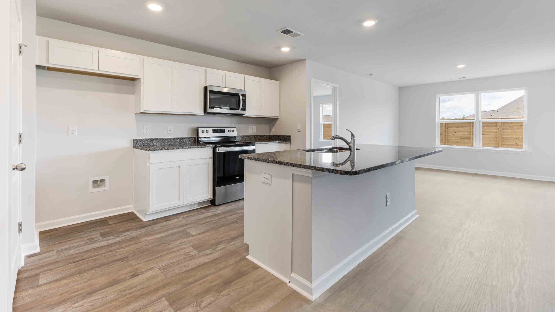 The kitchen features a large island, granite countertops, and stainless steel appliances, which are sure to both turn heads and make meal prep easy. You’ll never be too far from the action with the living and dining area right there.