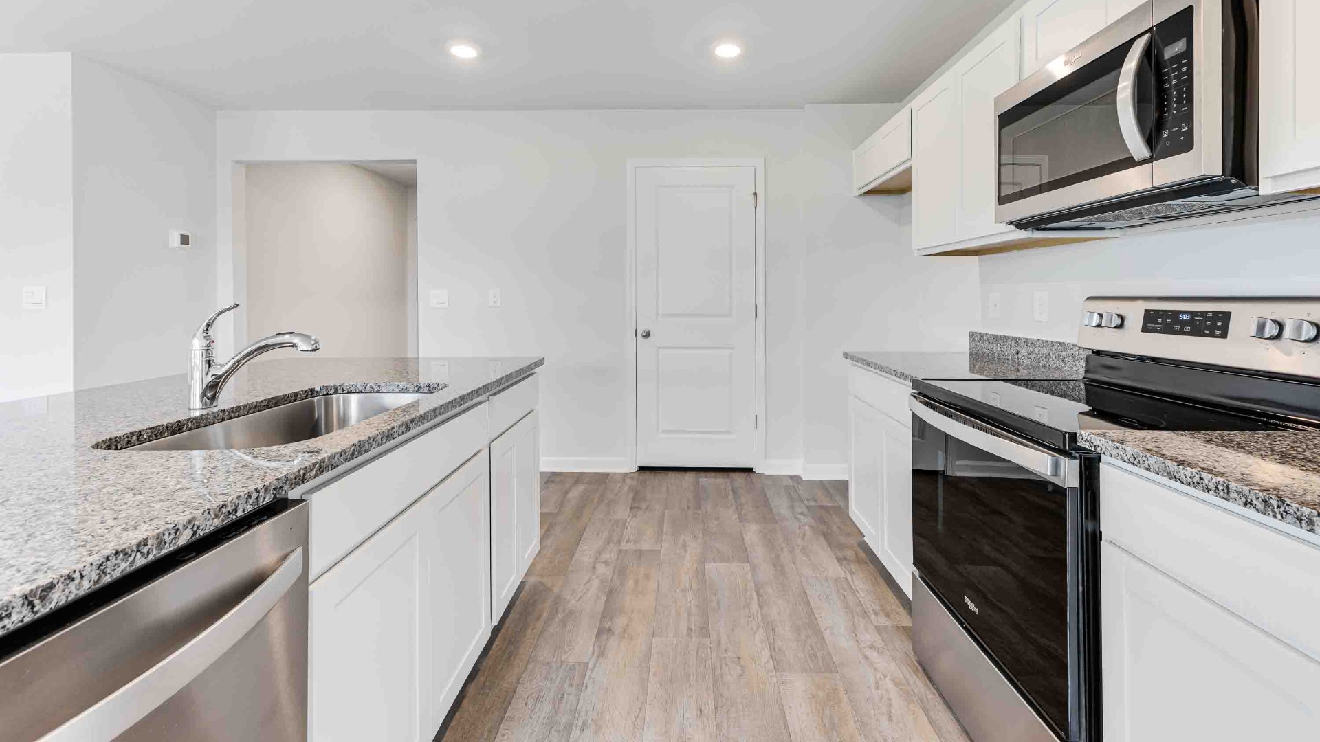 The kitchen features a large island, granite countertops, and stainless-steel appliances, which are sure to both turn heads and make meal prep easy. You’ll never be too far from the action with the living and dining area right there.