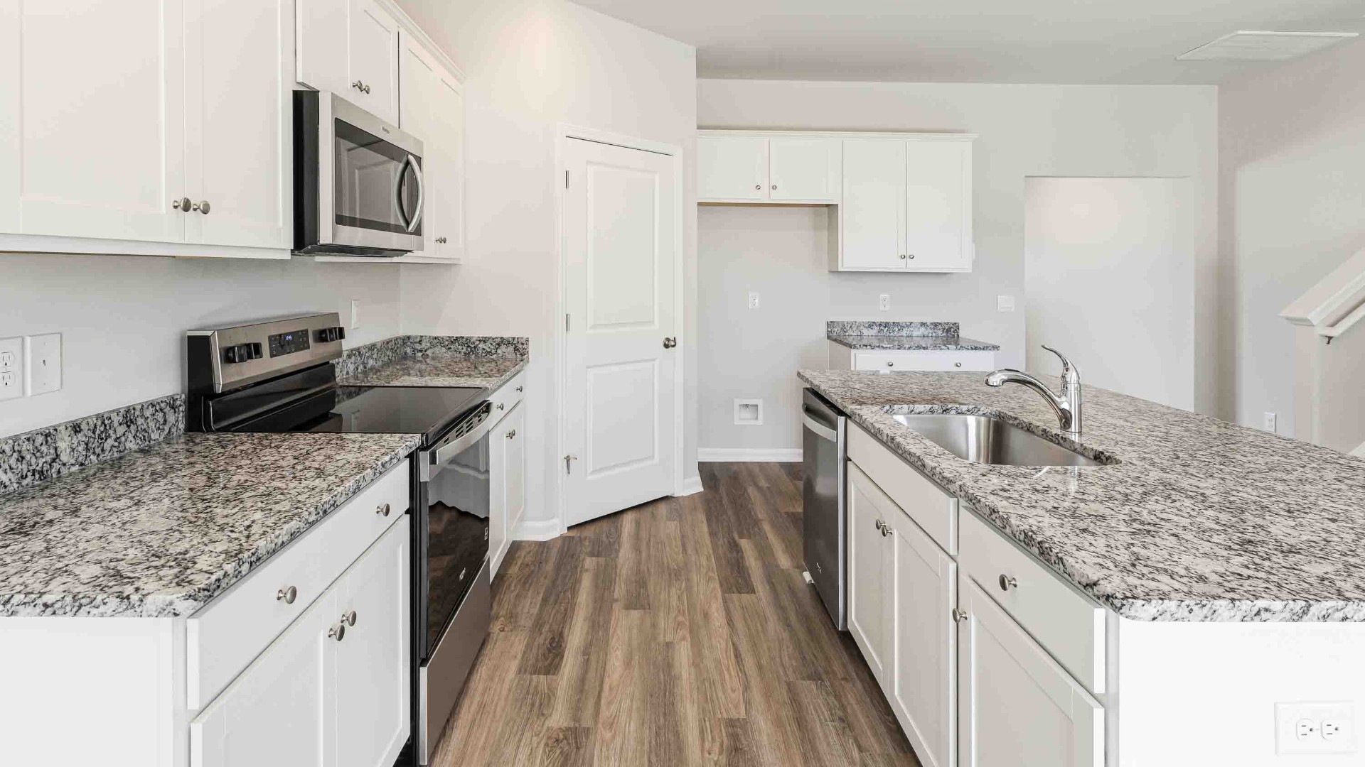 The open-concept kitchen features granite countertops and stainless-steel appliances. The large island is great for gatherings. The kitchen seamlessly connects to the dining and living areas, creating a great space for entertainment.