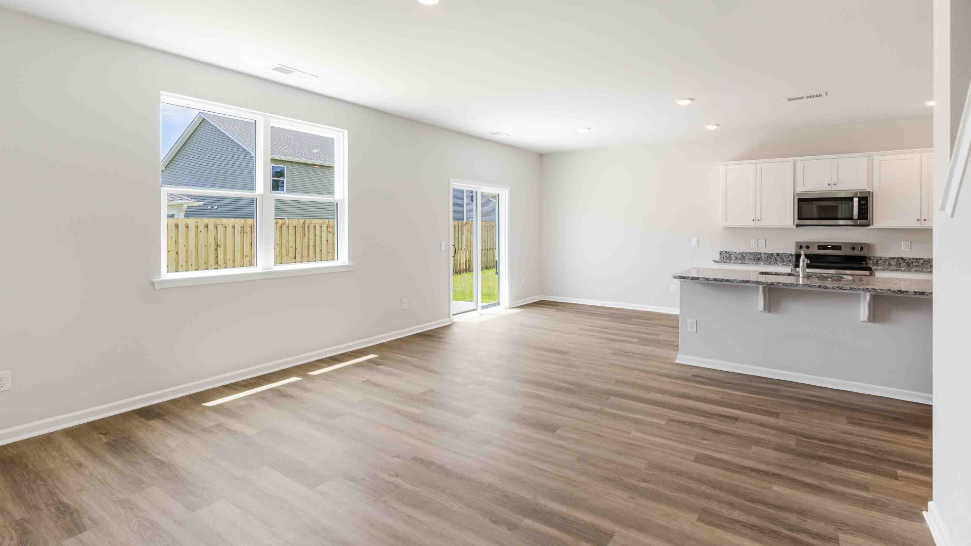 The open-concept kitchen features granite countertops and stainless-steel appliances. The large island is great for gatherings. The kitchen seamlessly connects to the dining and living areas, creating a great space for entertainment.