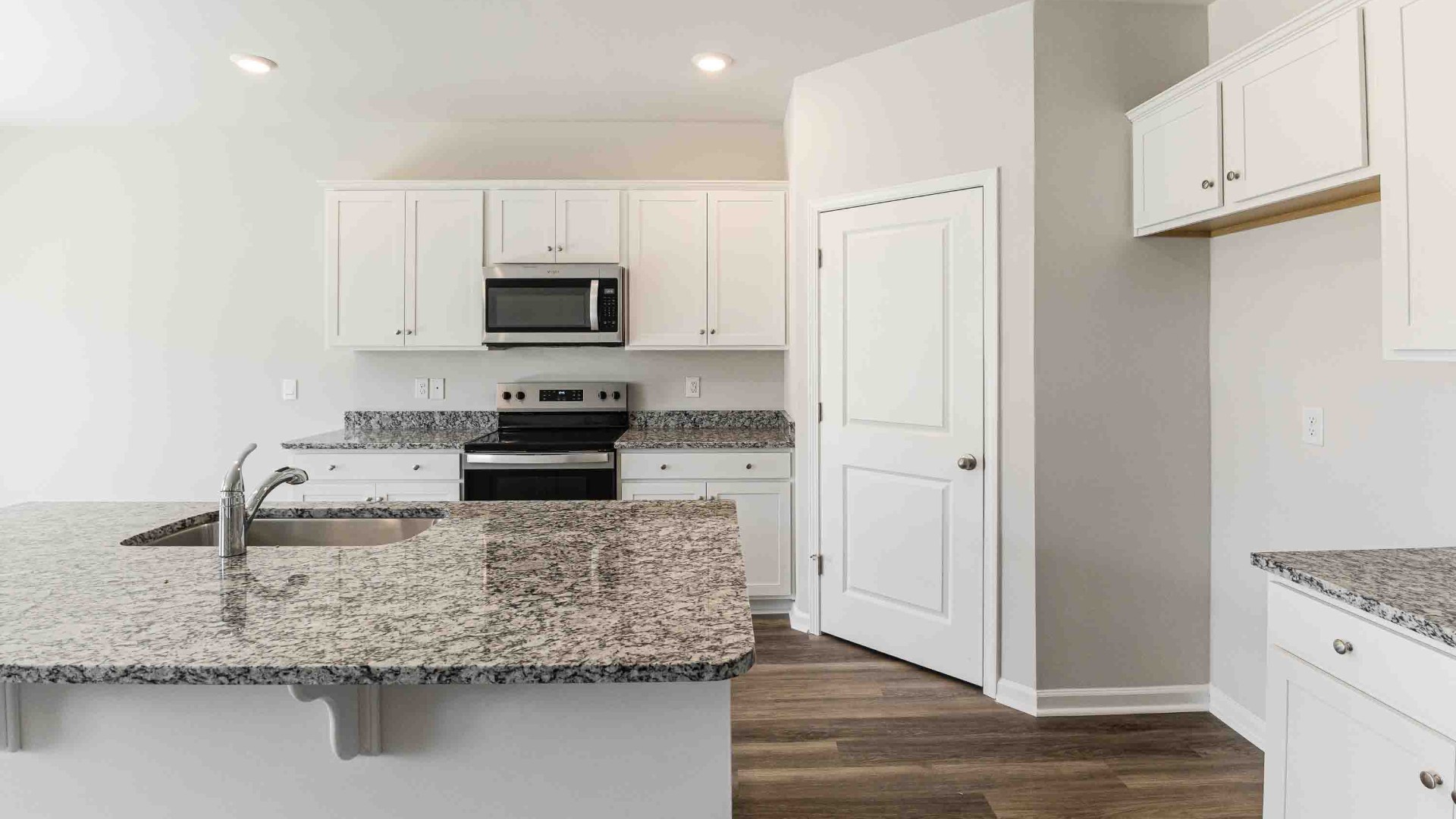 The open-concept kitchen features granite countertops and stainless-steel appliances. The large island is great for gatherings. The kitchen seamlessly connects to the dining and living areas, creating a great space for entertainment.