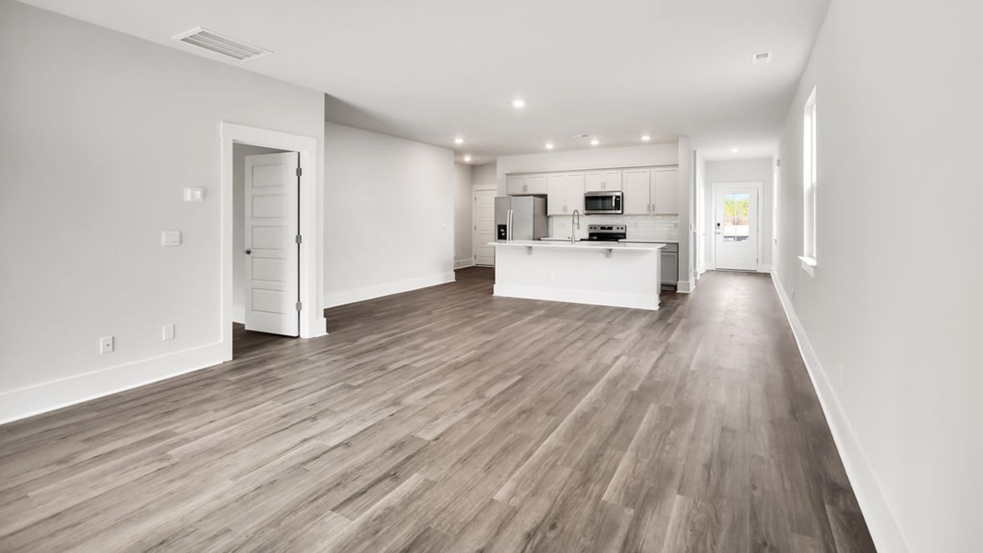 The heart of the home is its open concept kitchen with granite counters, stainless-steel appliances, and a generous island flowing into the dining and living areas.