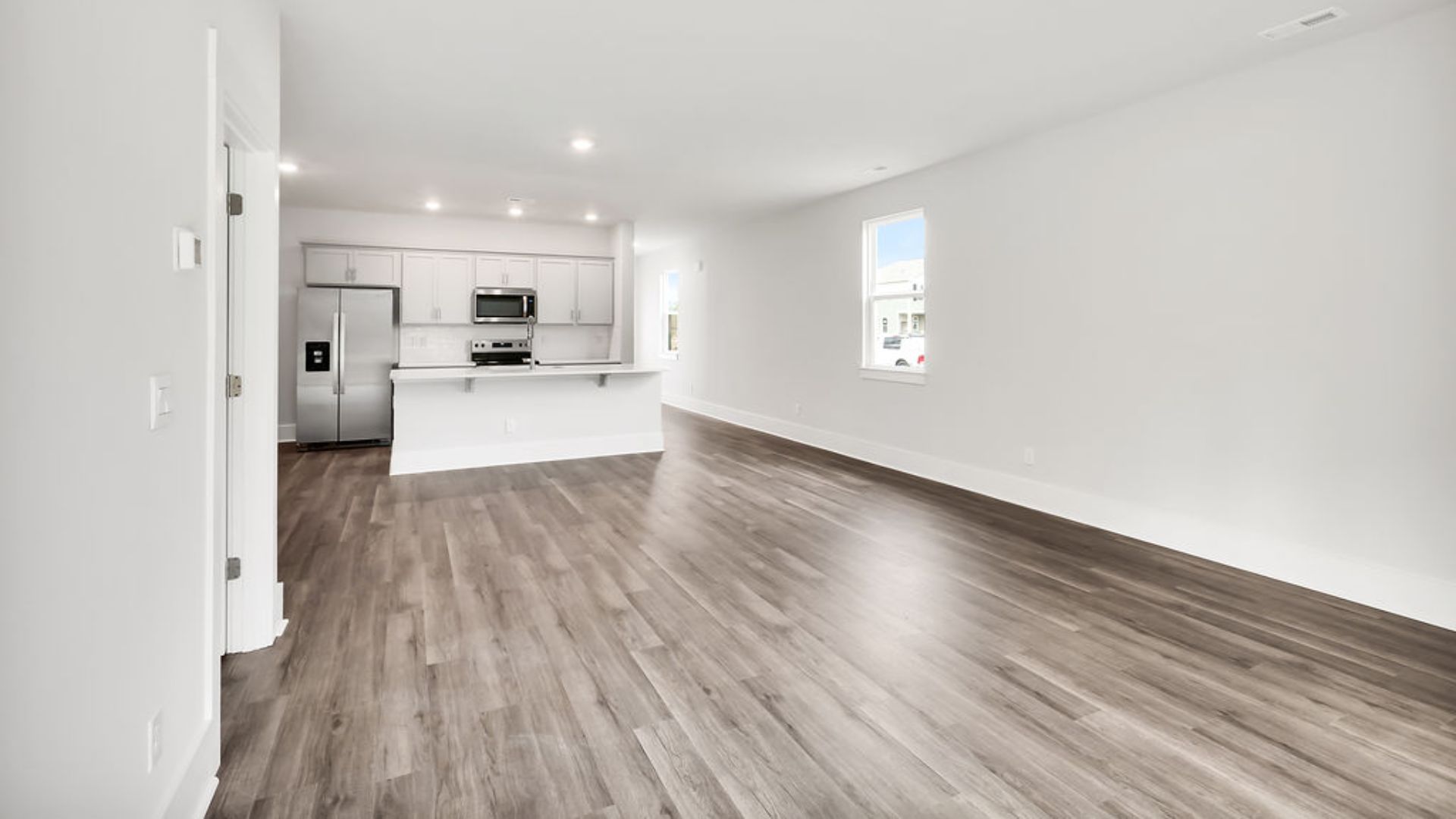 The heart of the home is its open concept kitchen with granite counters, stainless-steel appliances, and a generous island flowing into the dining and living areas.