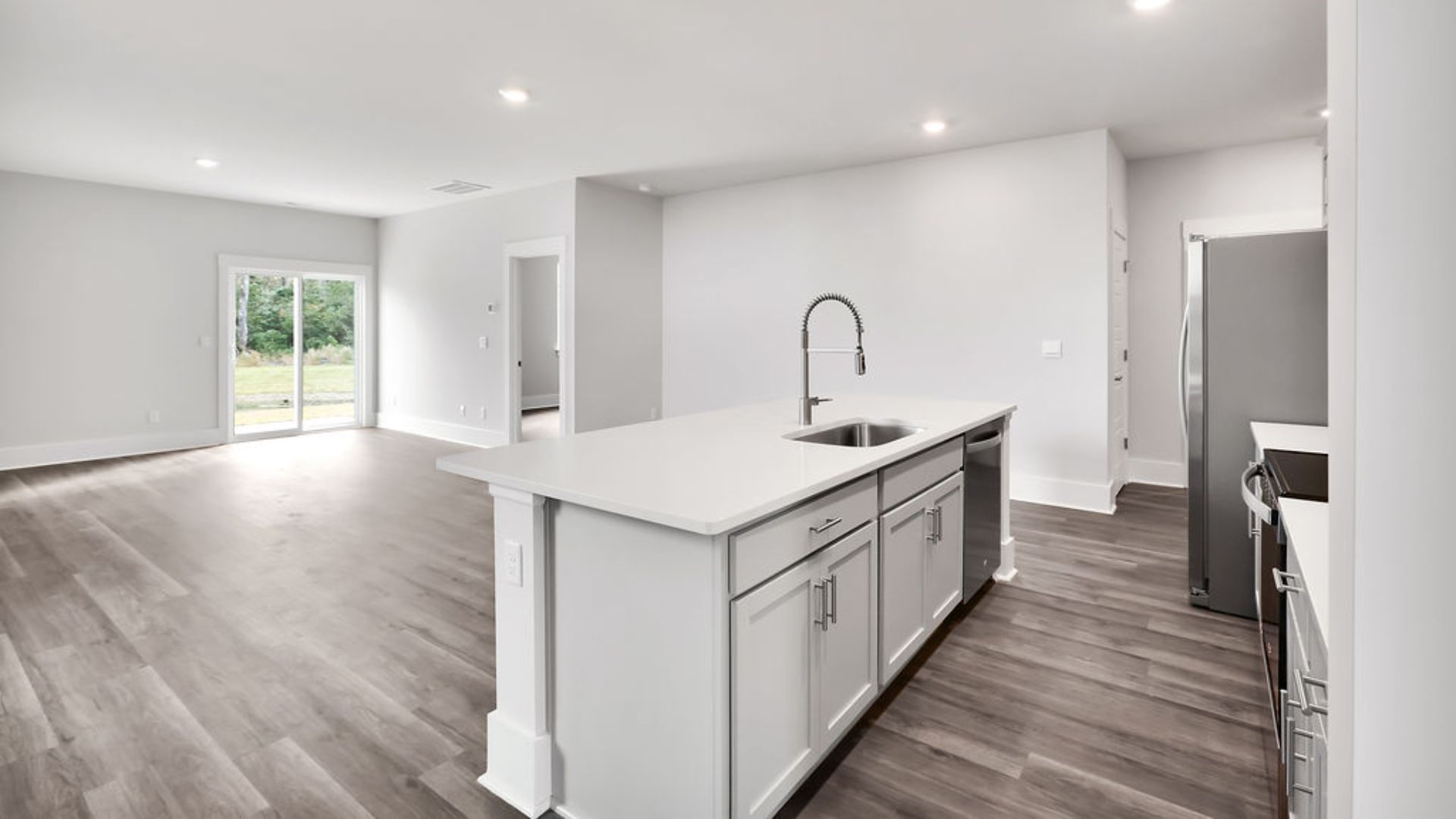 The heart of the home is its open concept kitchen with granite counters, stainless-steel appliances, and a generous island flowing into the dining and living areas.