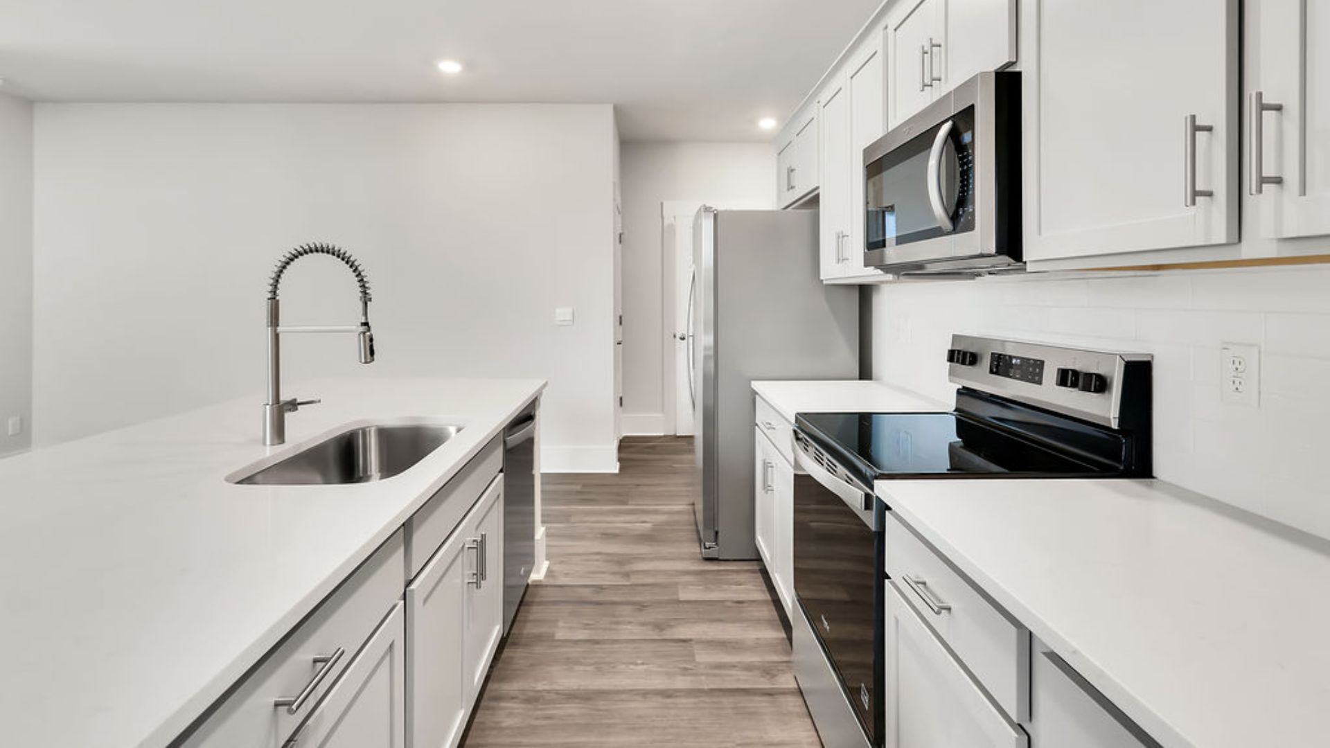 The heart of the home is its open concept kitchen with granite counters, stainless-steel appliances, and a generous island flowing into the dining and living areas.