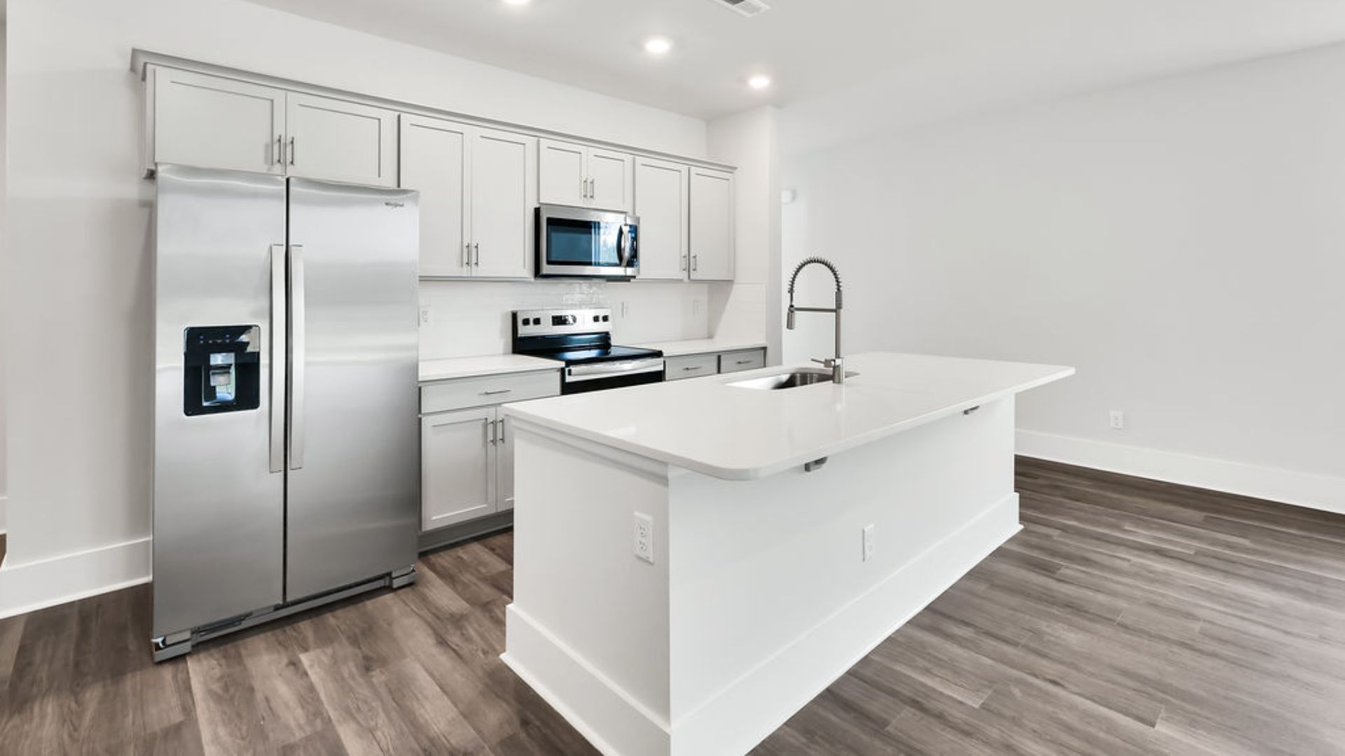 The heart of the home is its open concept kitchen with granite counters, stainless-steel appliances, and a generous island flowing into the dining and living areas.