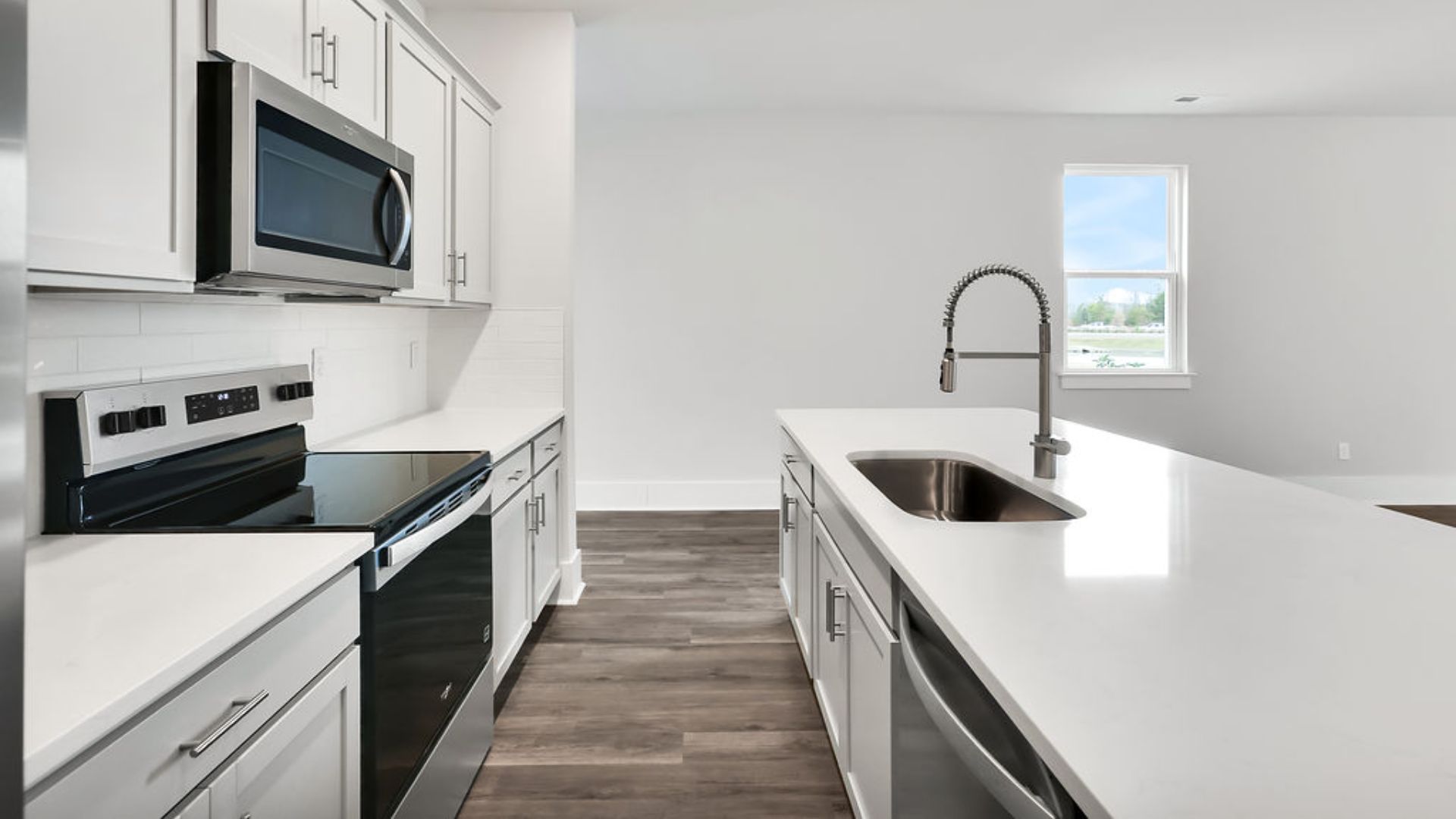 The heart of the home is its open concept kitchen with granite counters, stainless-steel appliances, and a generous island flowing into the dining and living areas.