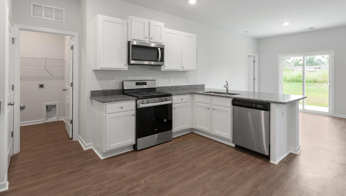 The open-concept layout begins with a welcoming foyer that leads into a spacious kitchen featuring a pantry and a convenient breakfast bar. The kitchen overlooks the living room, creating a bright, connected space.