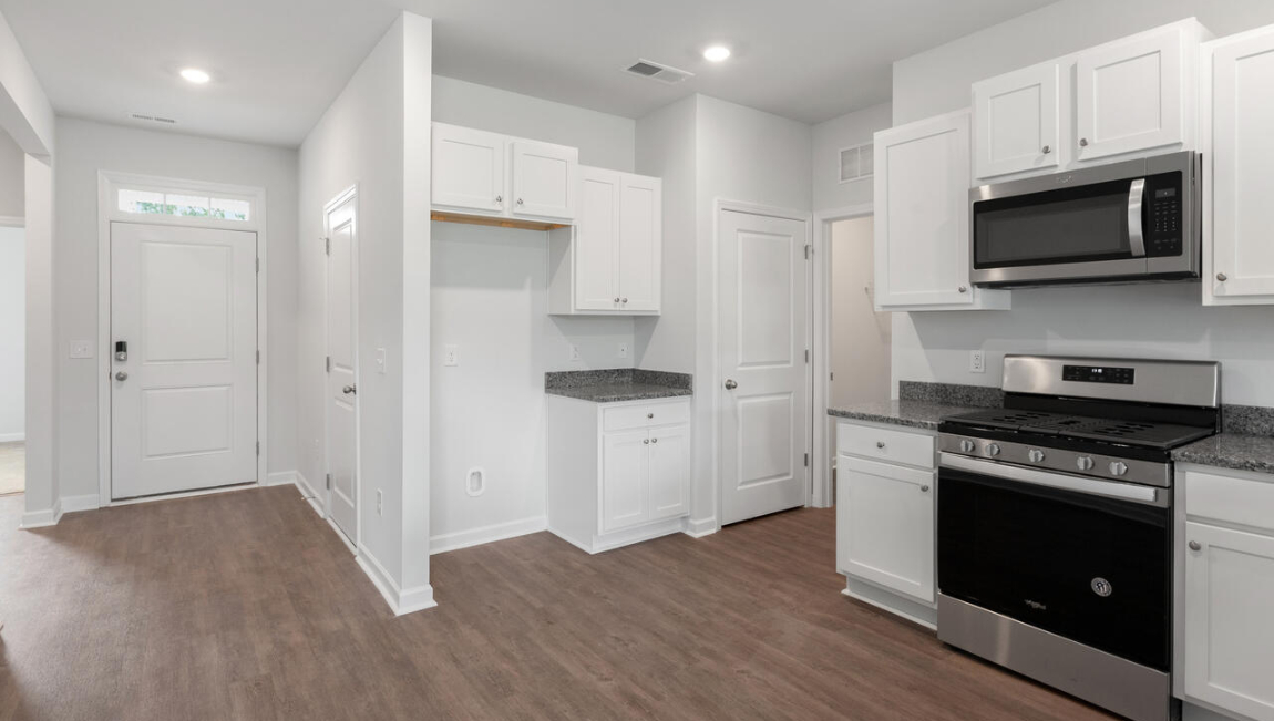 The open-concept layout begins with a welcoming foyer that leads into a spacious kitchen featuring a pantry and a convenient breakfast bar. The kitchen overlooks the living room, creating a bright, connected space.