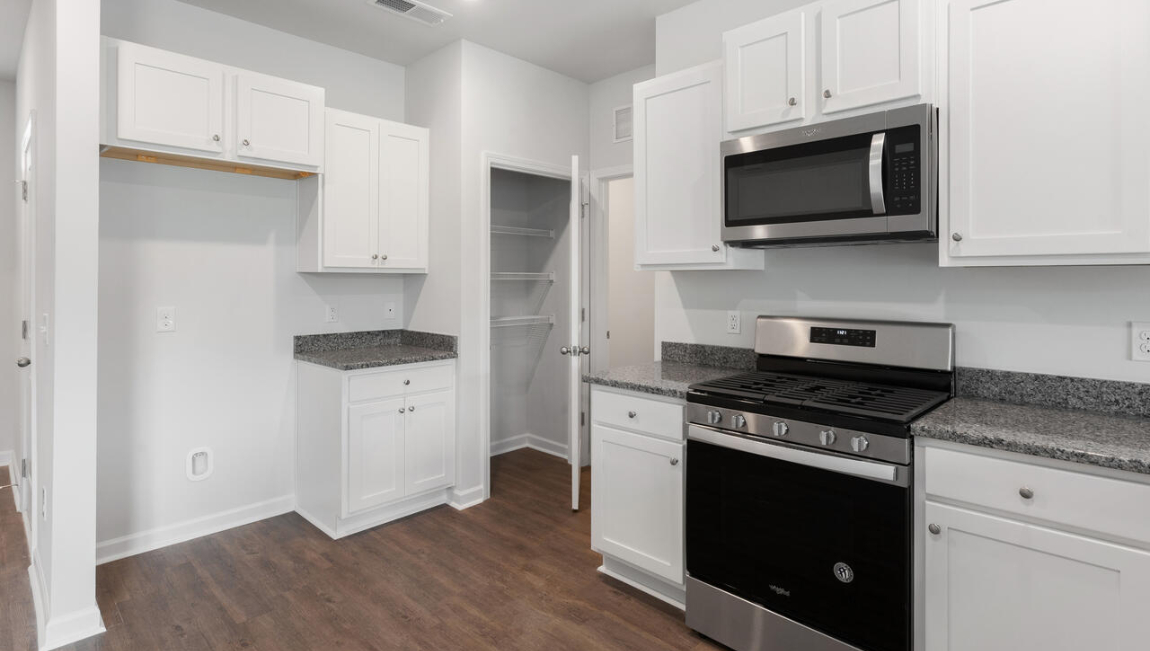 The open-concept layout begins with a welcoming foyer that leads into a spacious kitchen featuring a pantry and a convenient breakfast bar. The kitchen overlooks the living room, creating a bright, connected space.