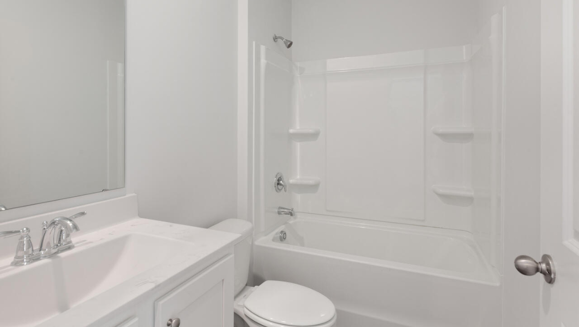. Two additional bedrooms at the front of the home share a full bath. A conveniently located laundry room near the kitchen adds to the home’s smart and practical design.