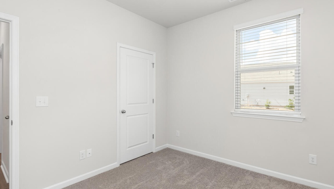 Two additional bedrooms at the front of the home share a full bath. A conveniently located laundry room near the kitchen adds to the home’s smart and practical design.