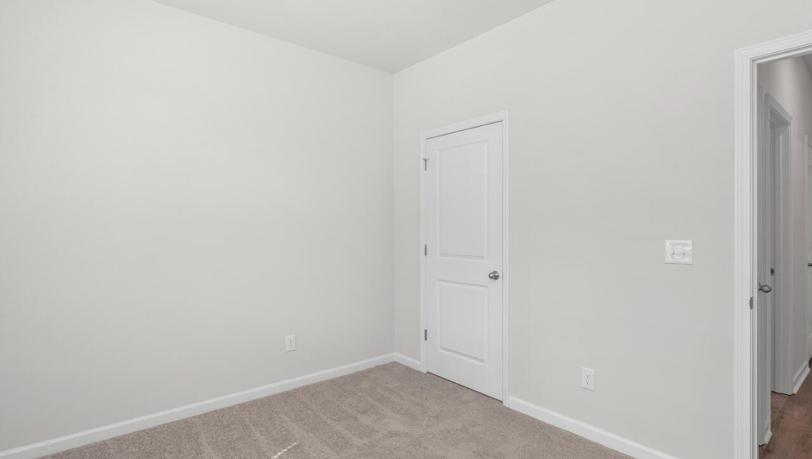Two additional bedrooms at the front of the home share a full bath. A conveniently located laundry room near the kitchen adds to the home’s smart and practical design.