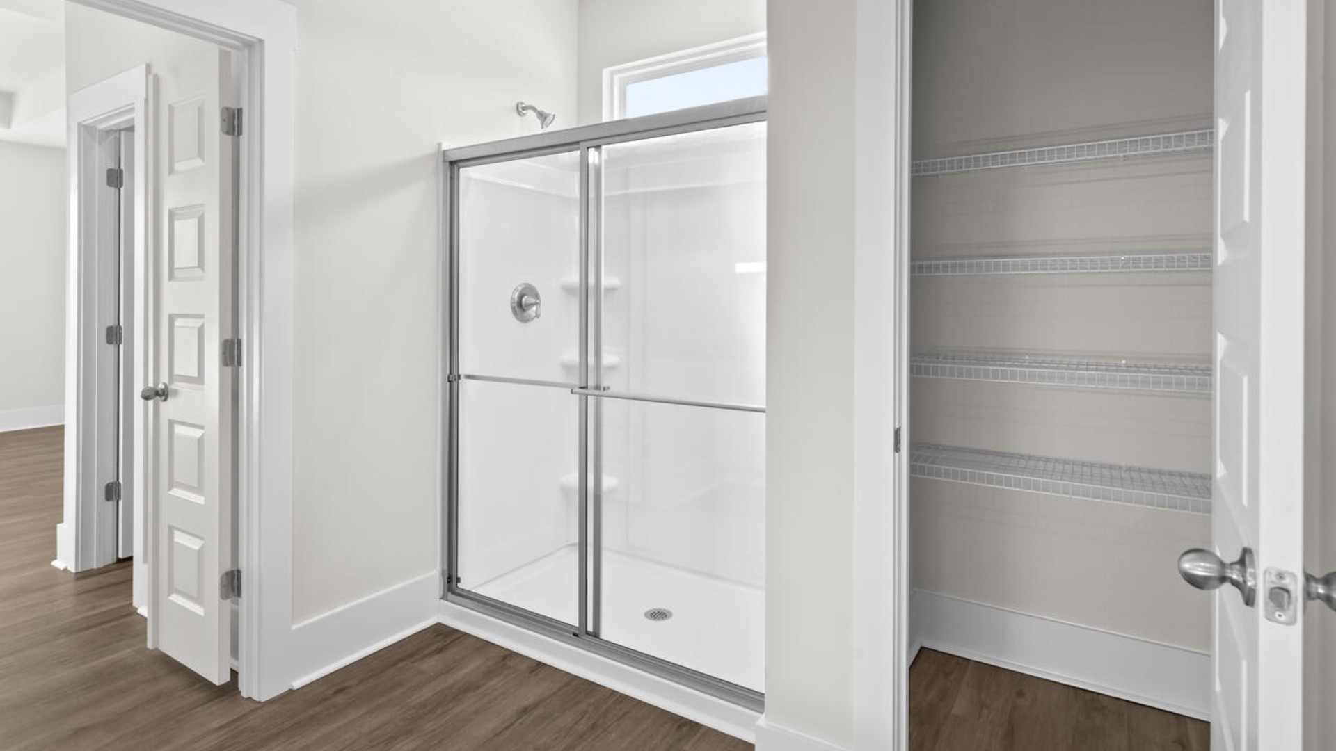 A large primary suite with bath that features separate sinks, quartz countertops and a large walk-in closet.