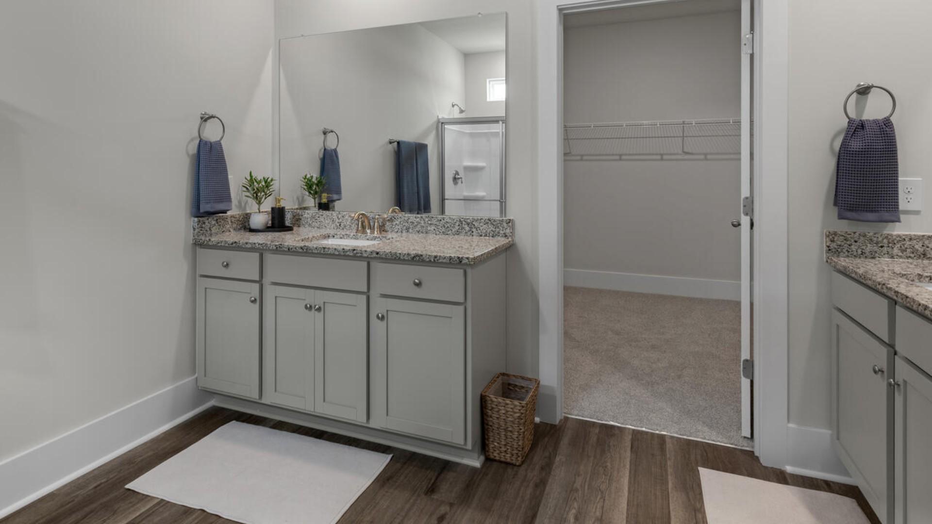 A large primary suite with bath that features separate sinks, granite countertops and a large walk-in closet.