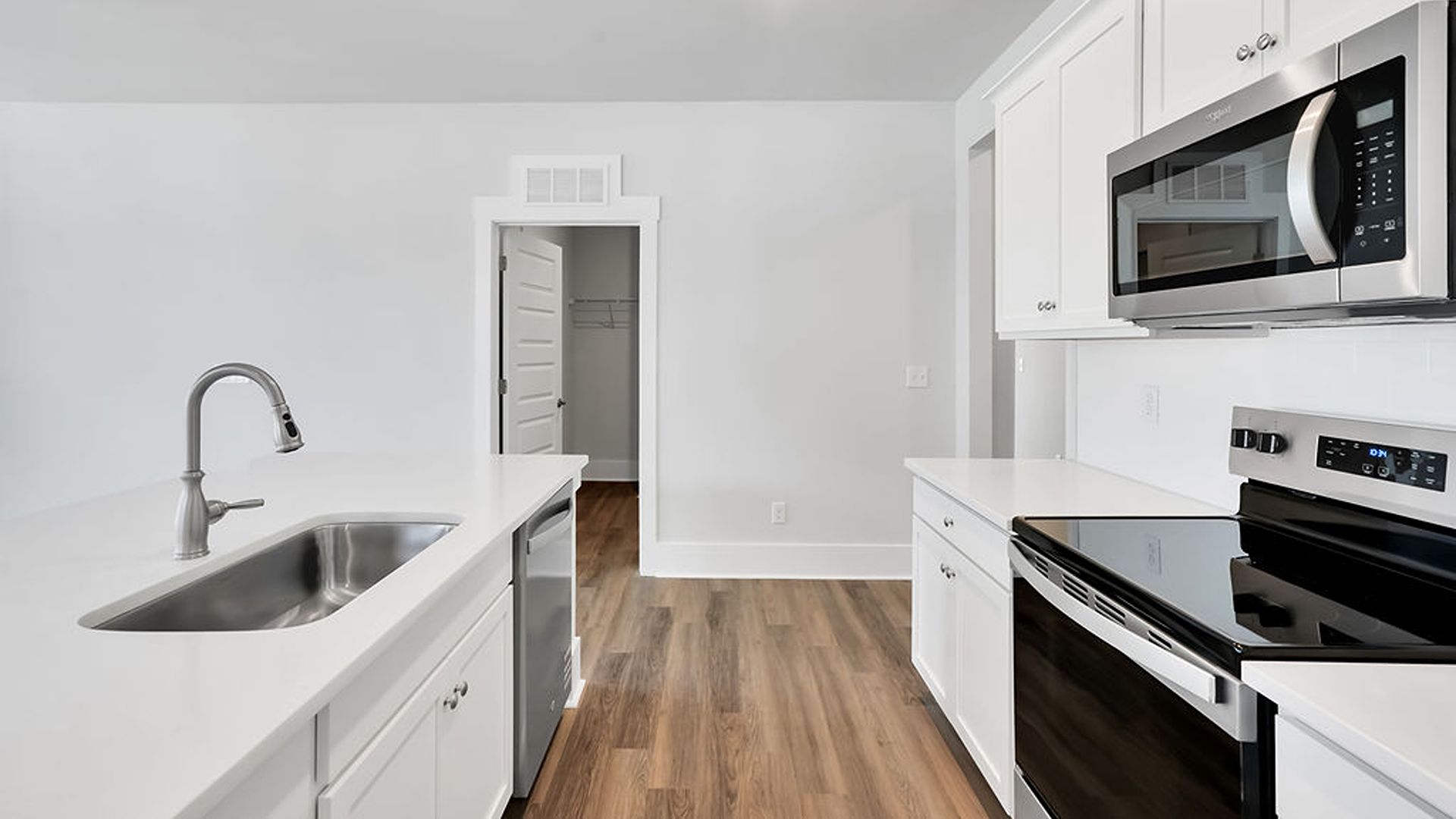 The kitchen features shaker-style cabinets, quartz countertops, and stainless-steel appliances, tile backsplash which are sure to both turn heads and make meal prep easy. You’ll never be too far from the action with the living and dining area right there.
