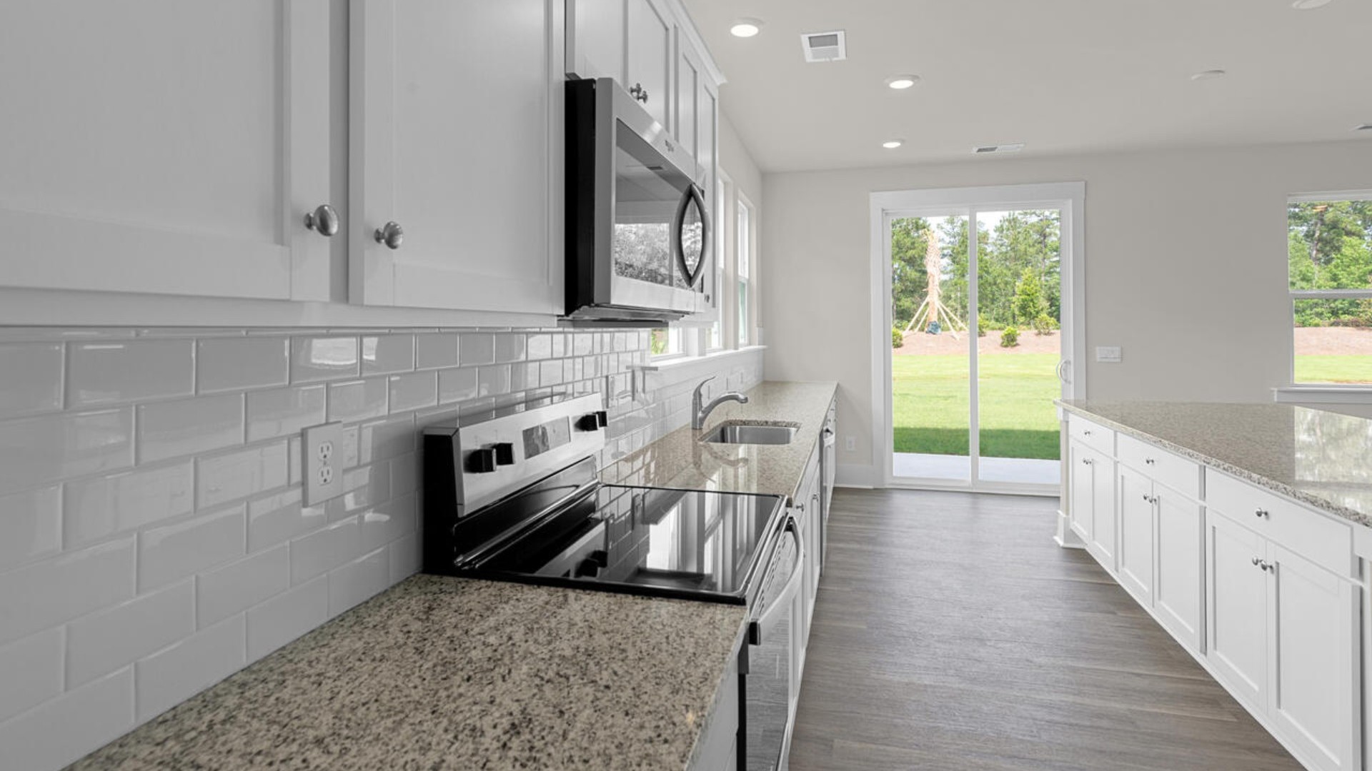 The kitchen features shaker-style cabinets and beautiful quartz countertops. The kitchen island is the perfect size for meal prep with a built-in sink and dishwasher. There’s also a large pantry and stainless steel appliances for function and style.