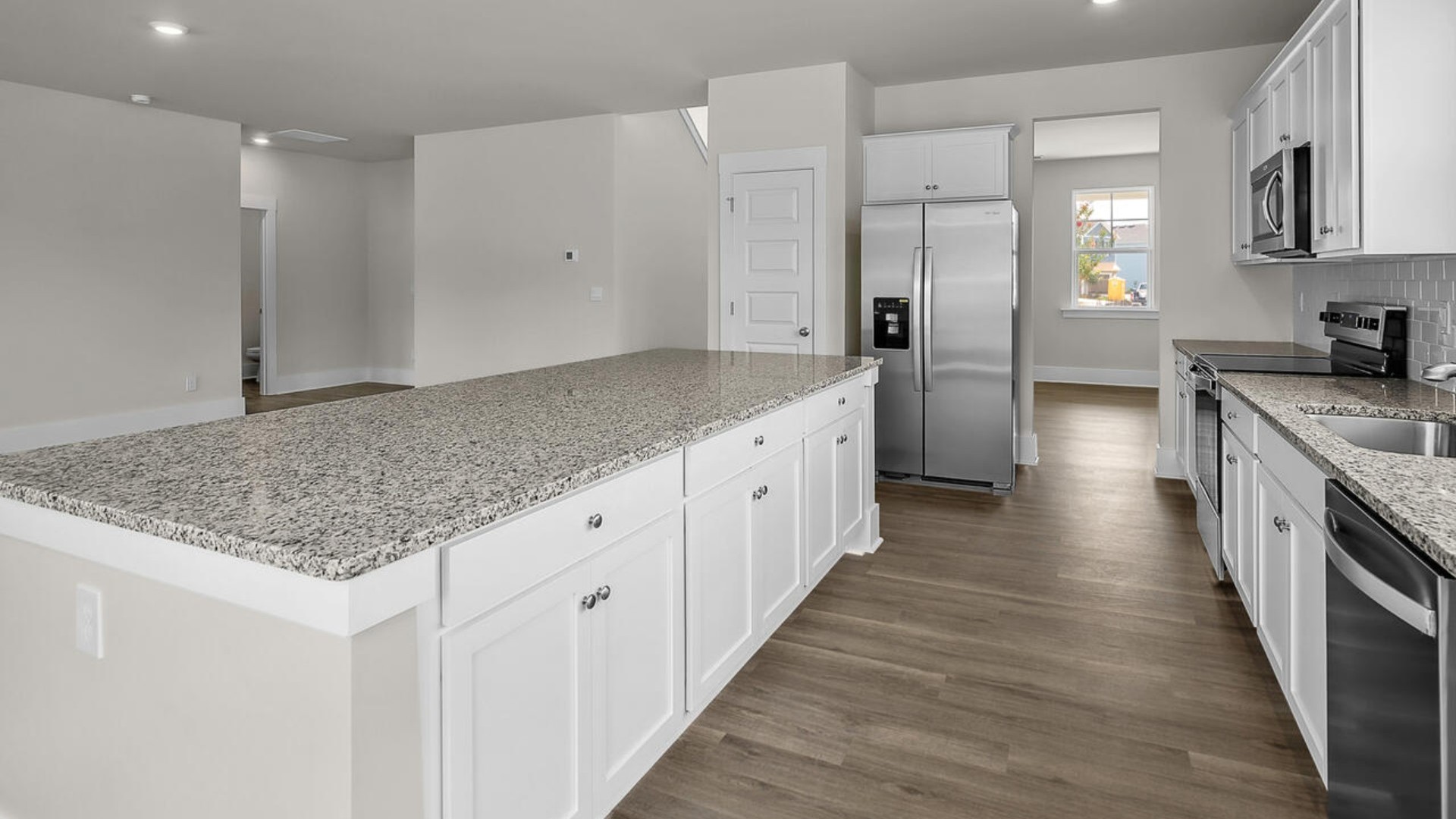 The kitchen features shaker-style cabinets and beautiful quartz countertops. The kitchen island is the perfect size for meal prep with a built-in sink and dishwasher. There’s also a large pantry and stainless steel appliances for function and style.