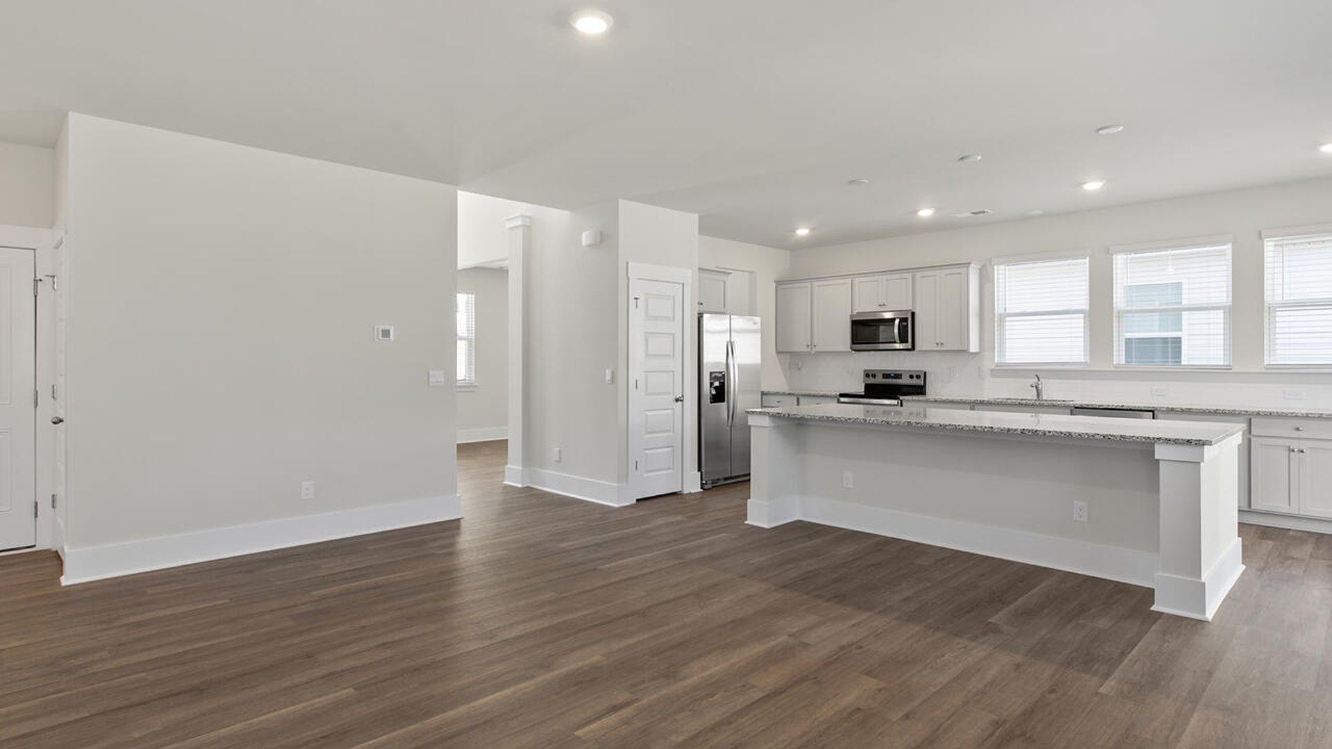 Featuring a formal dining room adjoining the kitchen, large island with quartz countertops, and open concept living space.