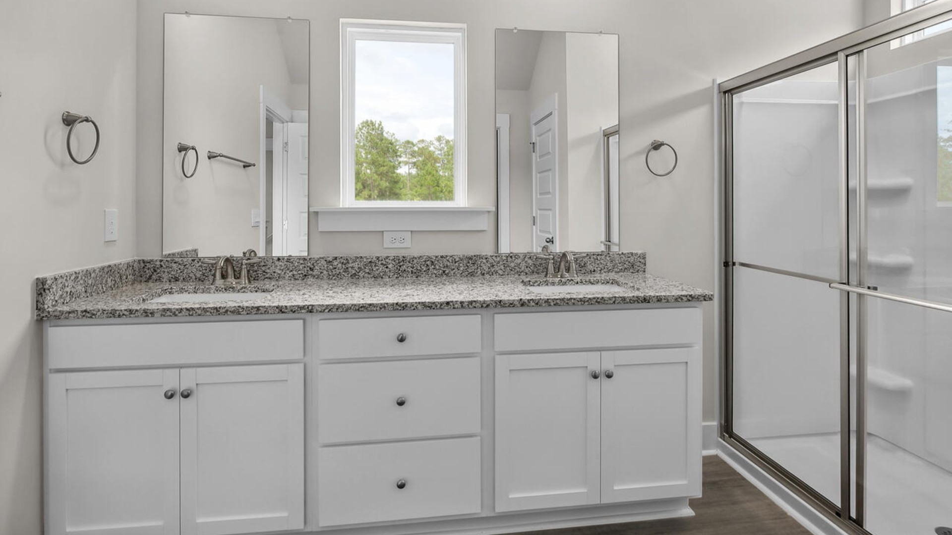 The primary suite features a sitting room, walk-in closet, trayed ceiling, a step-in 5-foot shower, dual vanity with granite countertops, and natural light in the bathroom.