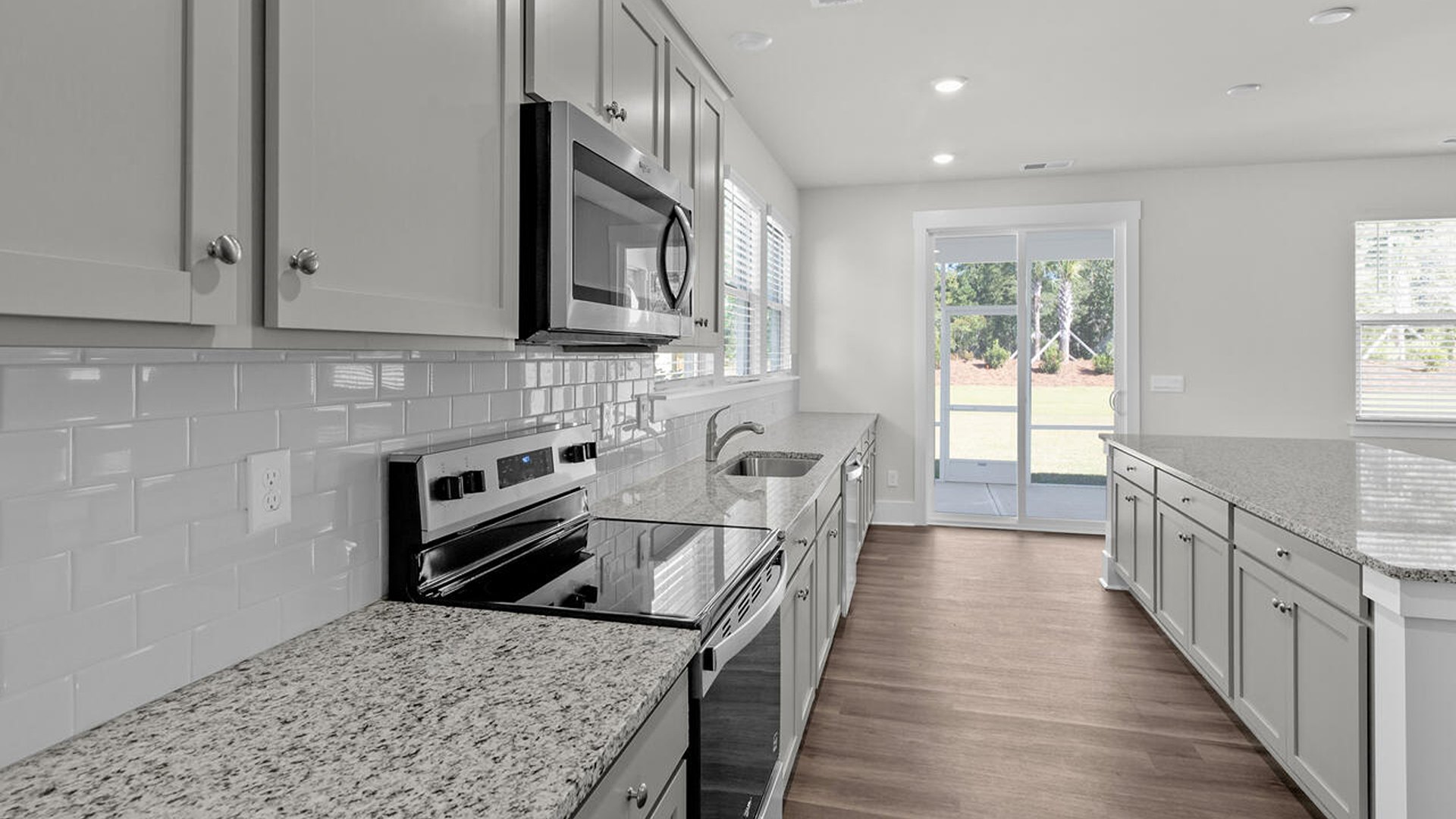 Featuring a formal dining room adjoining the kitchen, large island with granite countertops, and open concept living space.