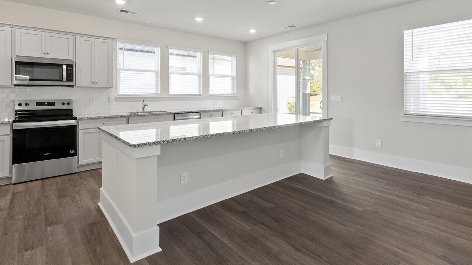 Featuring a formal dining room adjoining the kitchen, large island with granite countertops, and open concept living space.
