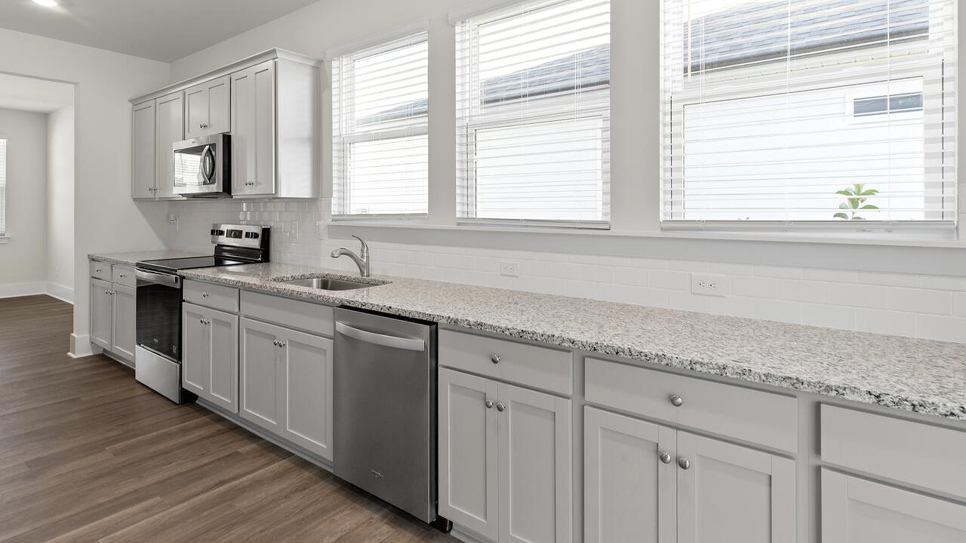 Featuring a formal dining room adjoining the kitchen, large island with granite countertops, and open concept living space.