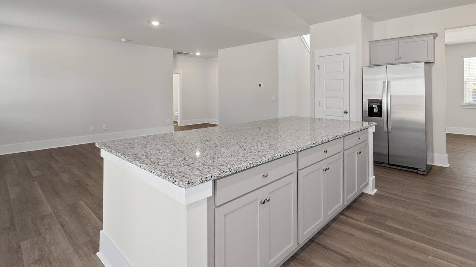 Featuring a formal dining room adjoining the kitchen, large island with granite countertops, and open concept living space.