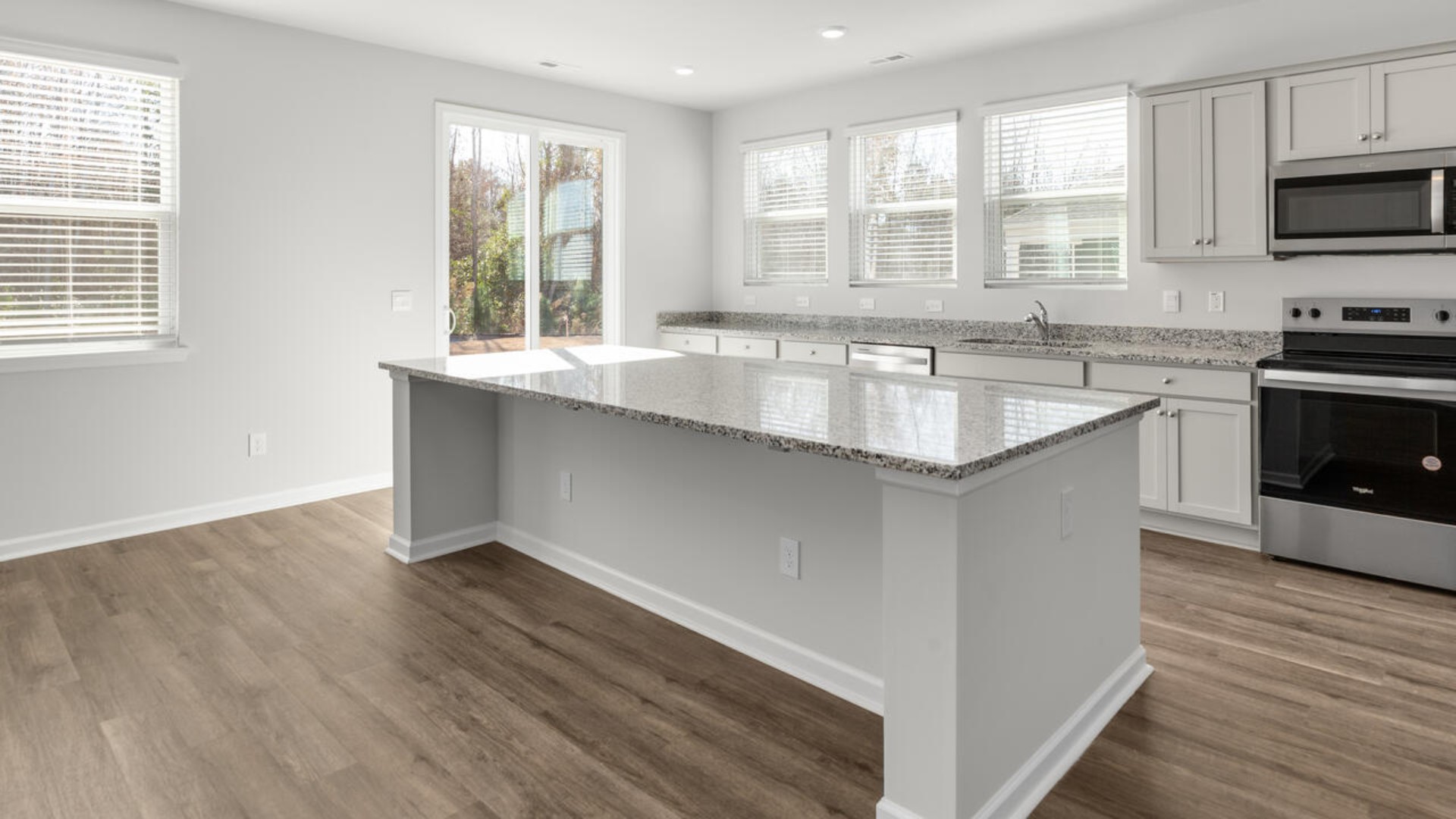 The kitchen features shaker-style cabinets and beautiful quartz countertops. The kitchen island is the perfect size for meal prep with a built-in sink and dishwasher. There’s also a large pantry and stainless steel appliances for function and style.