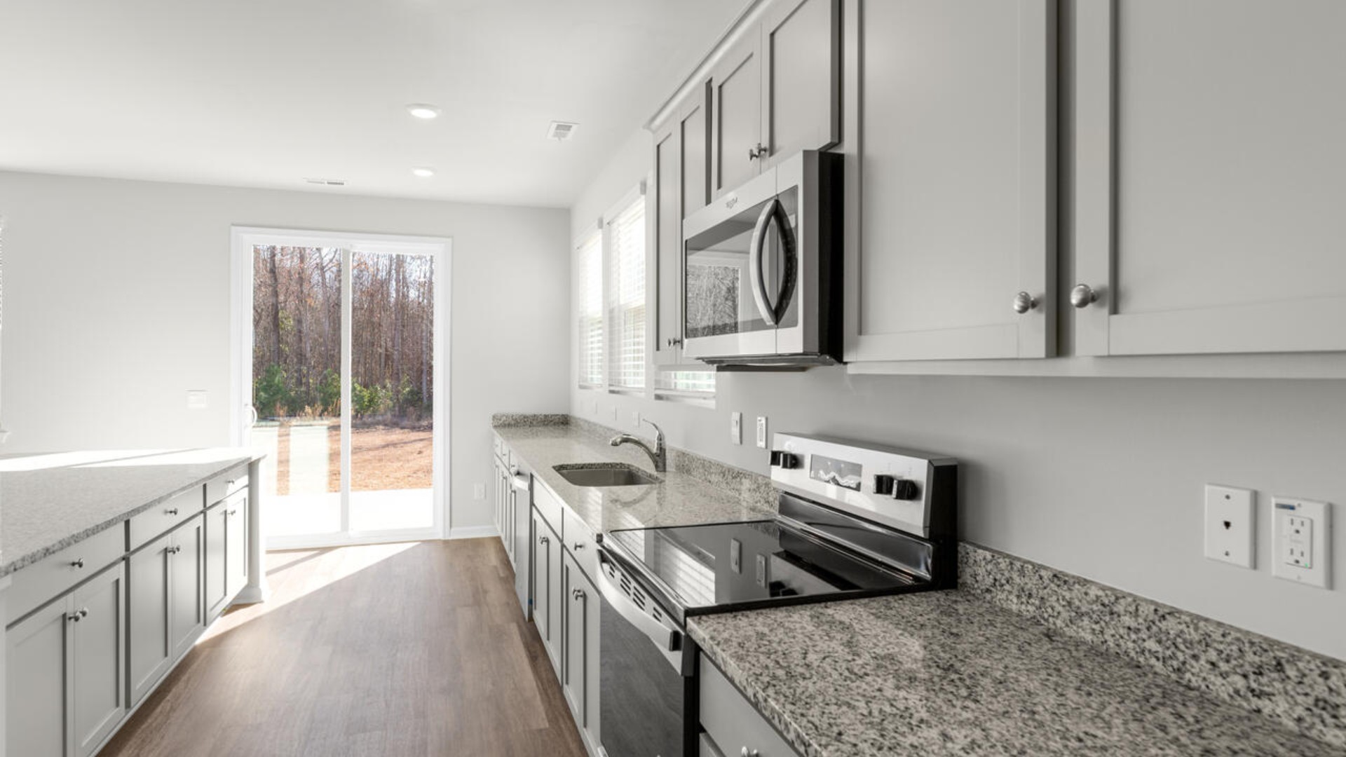 The kitchen features shaker-style cabinets and beautiful quartz countertops. The kitchen island is the perfect size for meal prep with a built-in sink and dishwasher. There’s also a large pantry and stainless steel appliances for function and style.