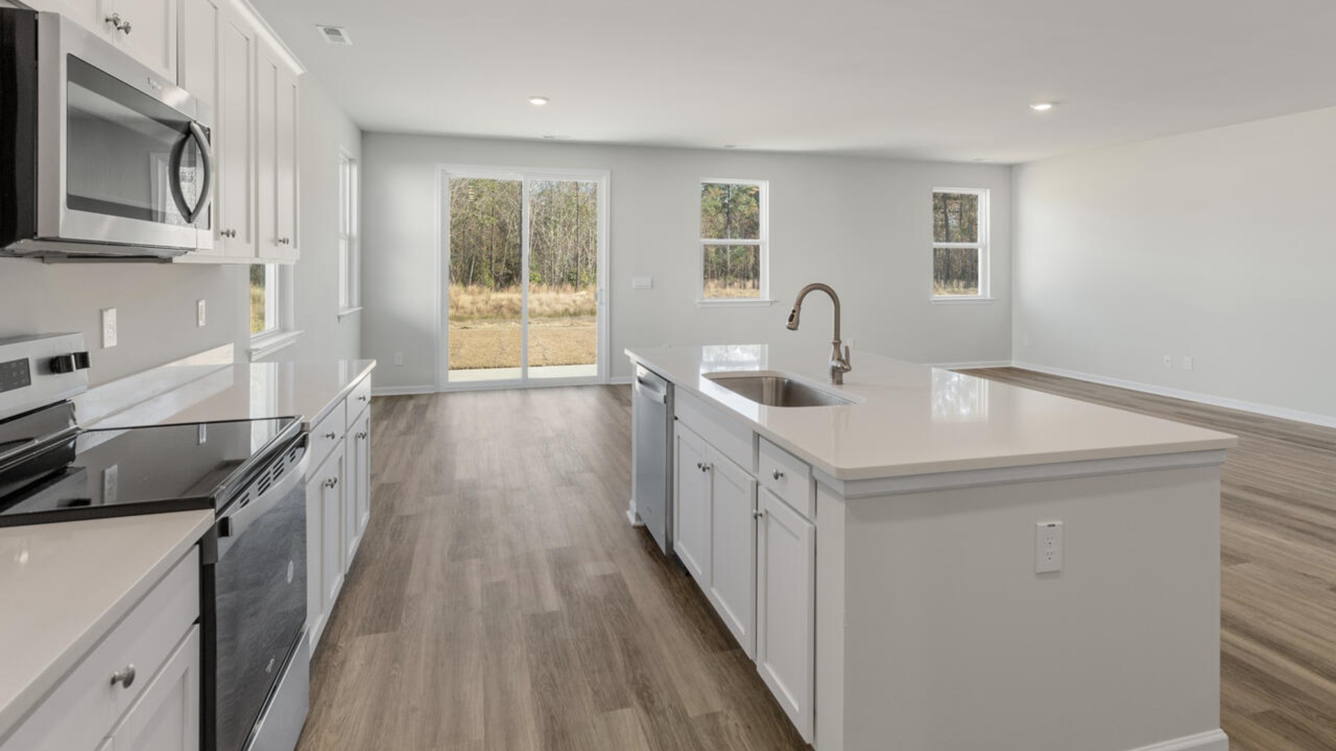 The butler’s pantry leads you into the massive kitchen and offers elegance and convenience, perfect for hosting dinner parties or holiday meals. The kitchen is open and expansive with a large island that overlooks the living room and the eat in kitchen area. Tucked away behind the living room is a private downstairs bedroom and full bathroom.
