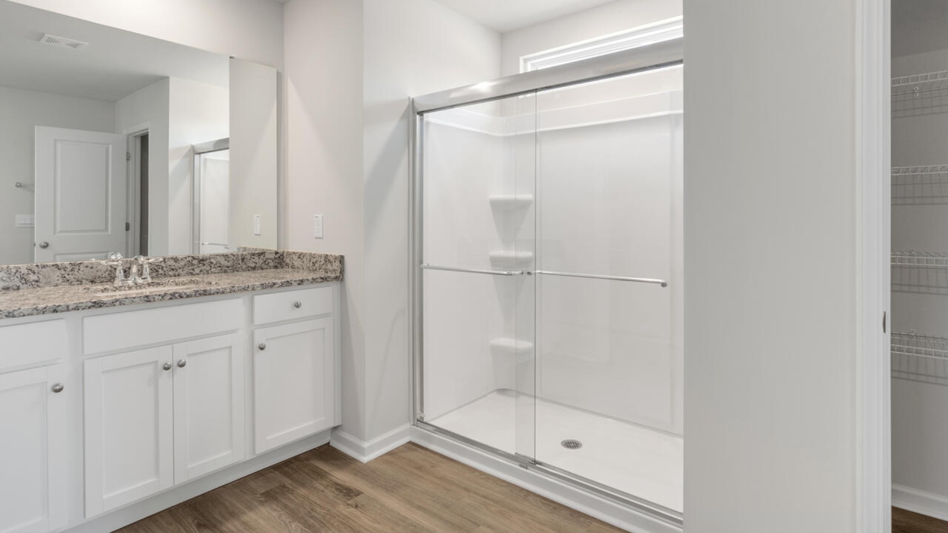 The primary suite spans the whole back of the home with a sitting room. The primary suite bath features a step-in 5' shower and a dual vanity.