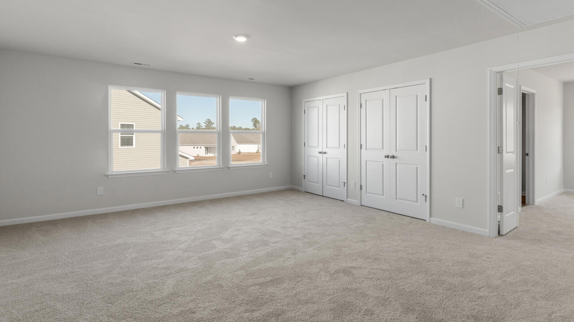 The primary suite spans the whole back of the home with a sitting room. The primary suite bath features a step-in 5' shower and a dual vanity.