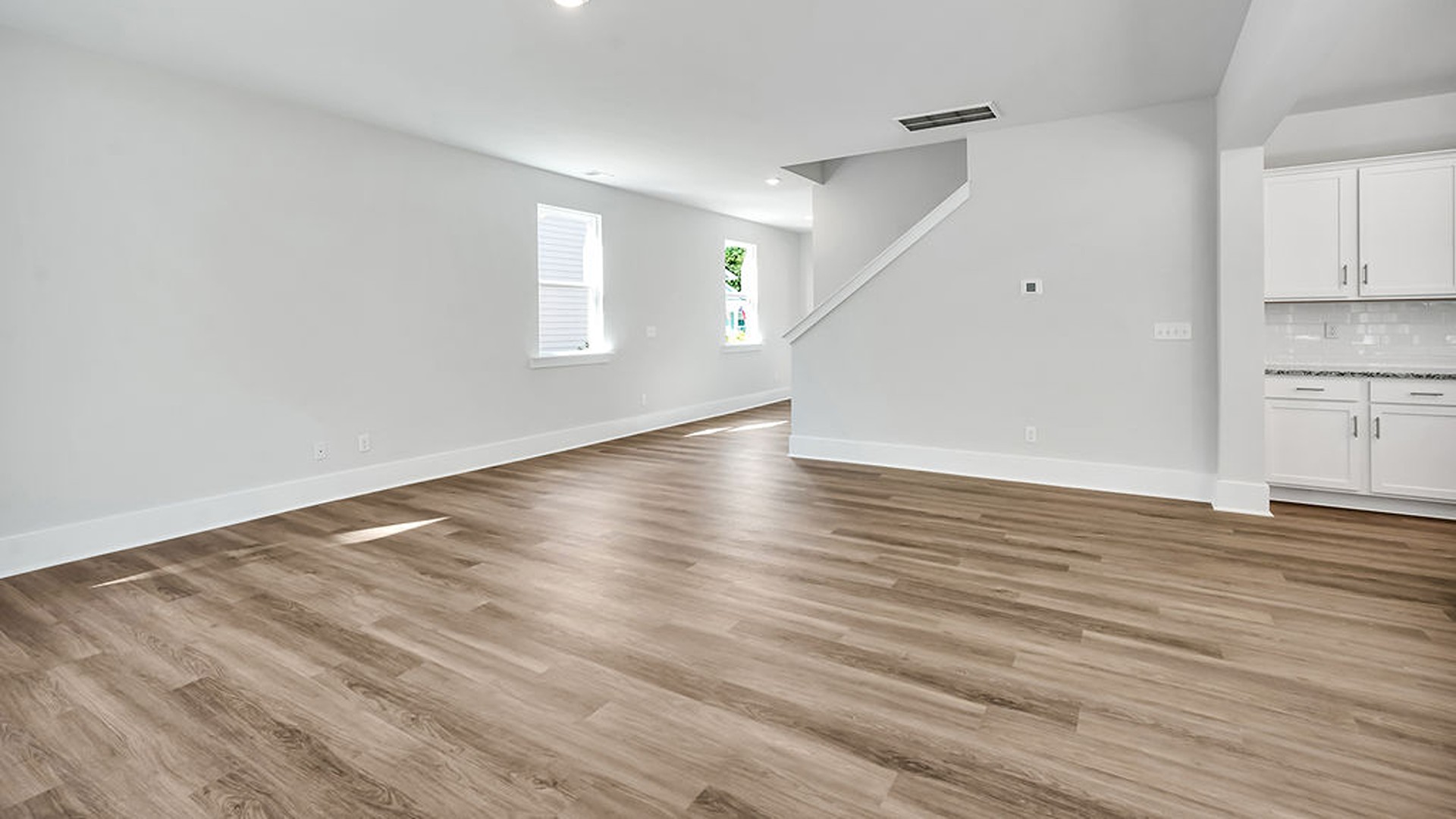 The gourmet kitchen serves as the focal point, anchored by a grand center island with seating, a walk-in pantry, and a seamless flow into the living room—complete with an optional fireplace.
