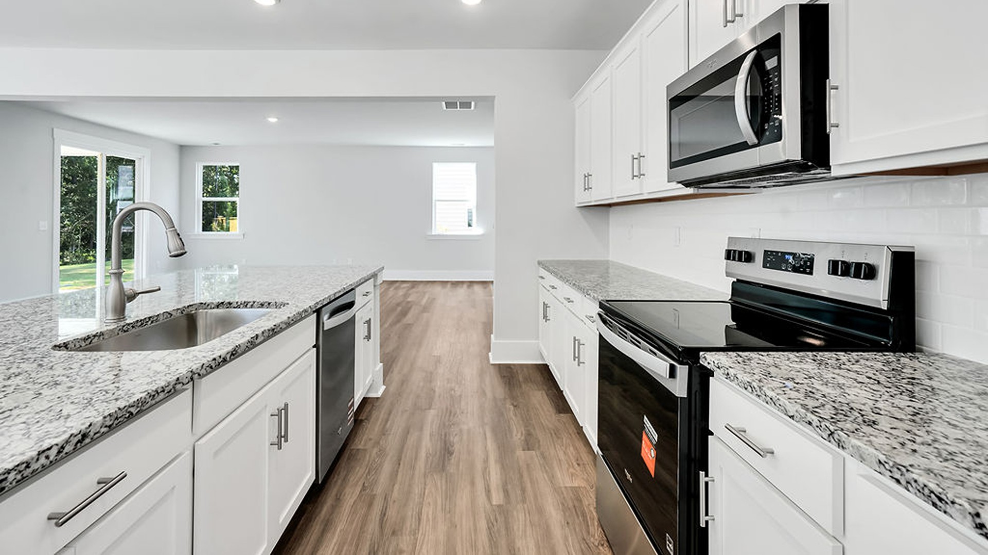 The gourmet kitchen serves as the focal point, anchored by a grand center island with seating, a walk-in pantry, and a seamless flow into the living room—complete with an optional fireplace.