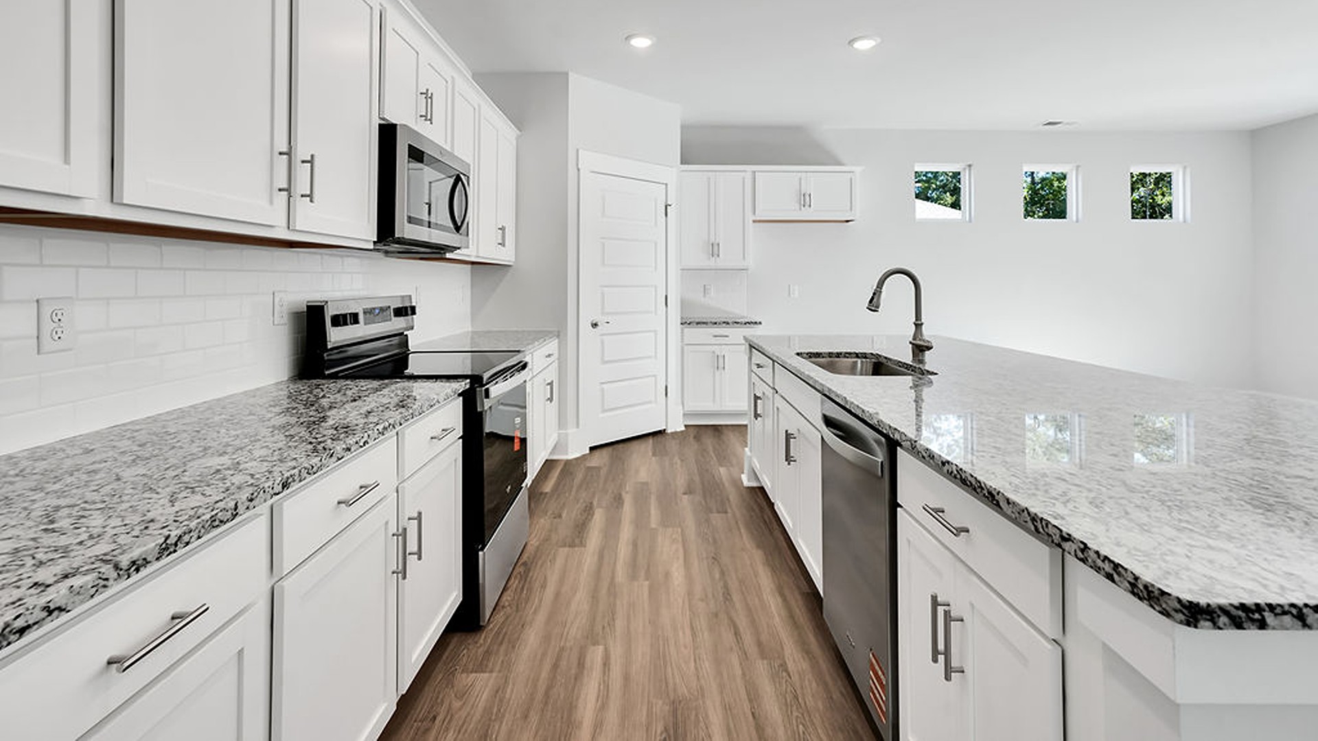 The gourmet kitchen serves as the focal point, anchored by a grand center island with seating, a walk-in pantry, and a seamless flow into the living room—complete with an optional fireplace.