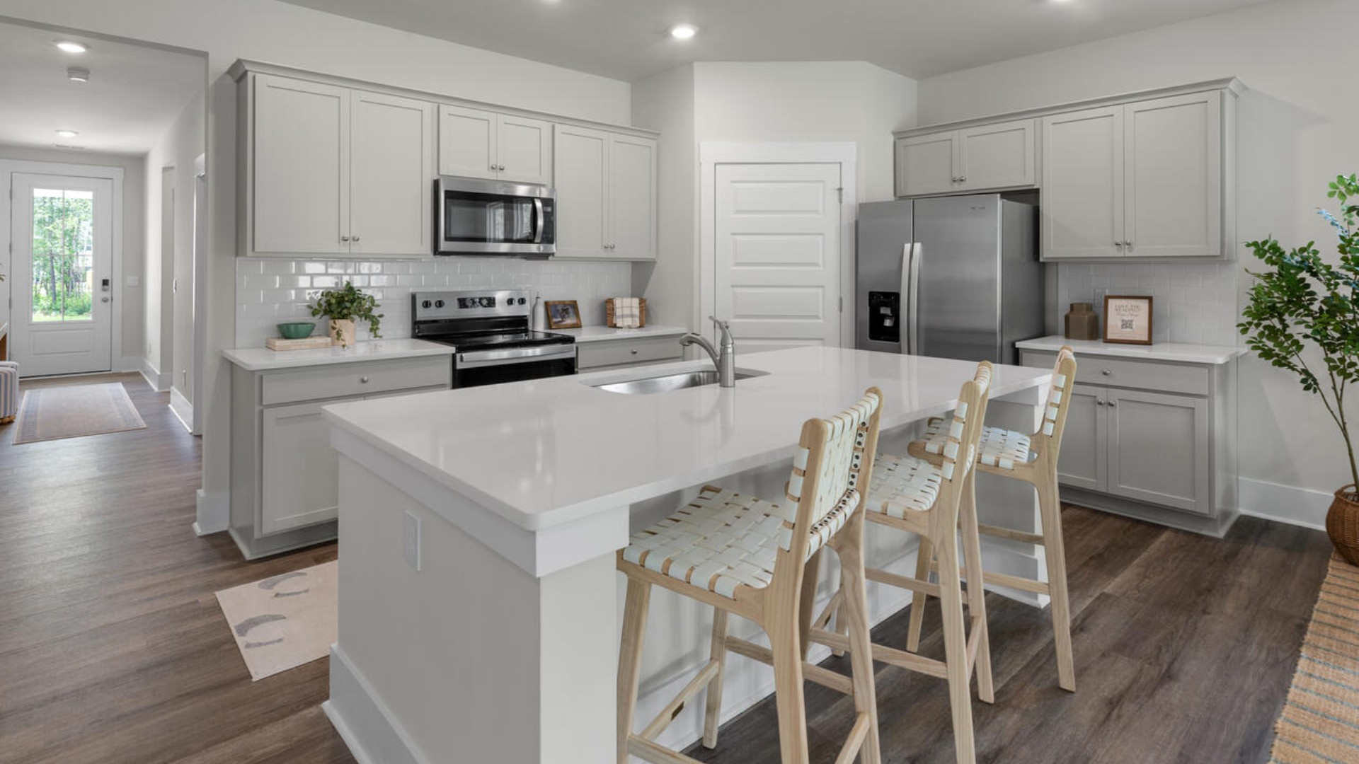 The kitchen features shaker-style cabinets, quartz countertops, and stainless steel appliances, which are sure to both turn heads and make meal prep easy. You’ll never be too far from the action with the living and dining area right there.